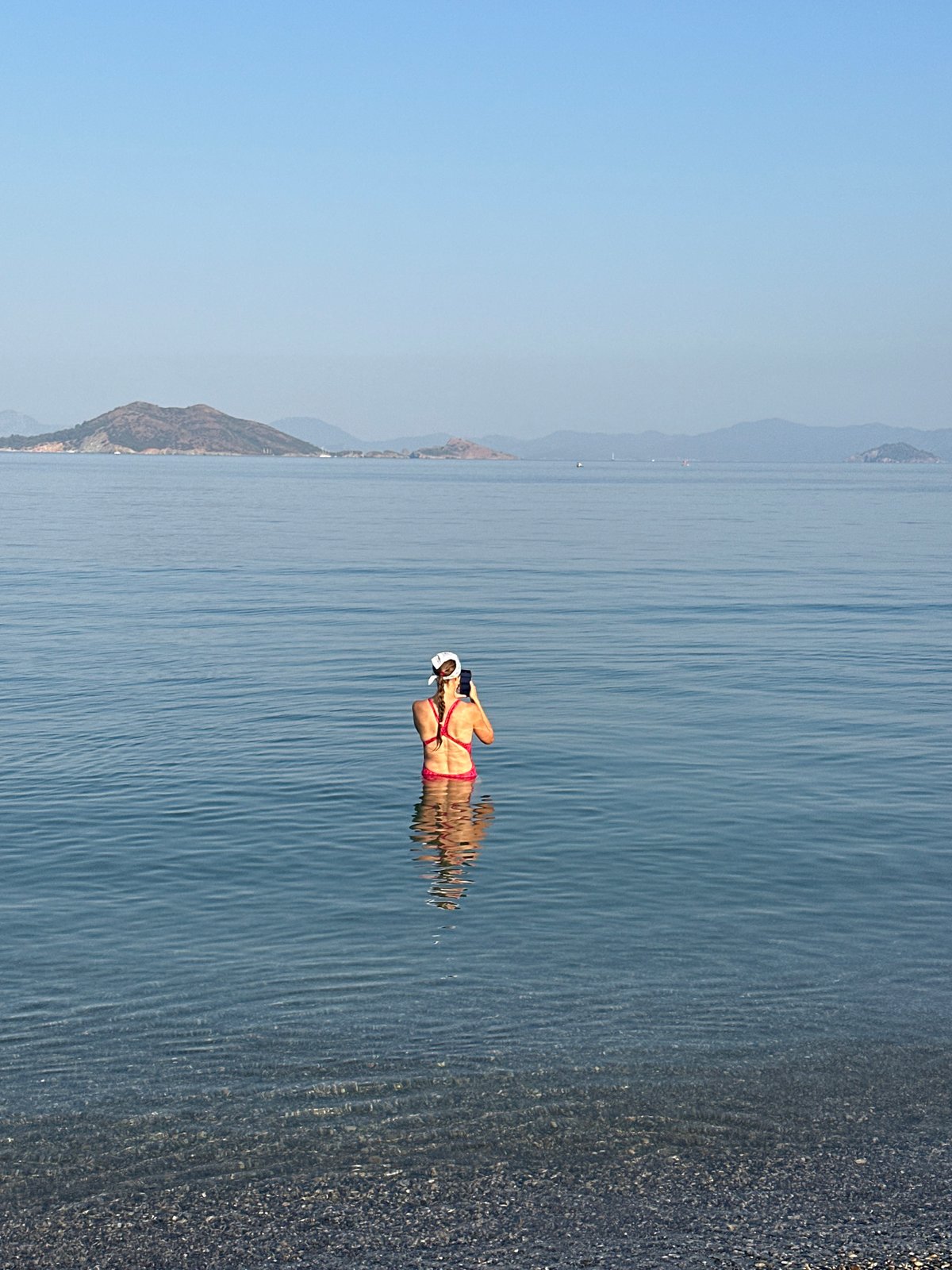 Calm morning at a Fethiye pebble beach and bay
