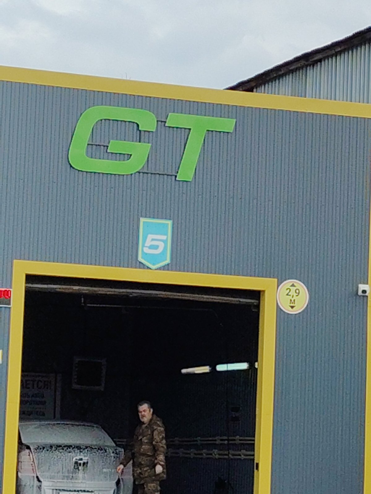 Car wash facility observed with numbered bays, yellow trim