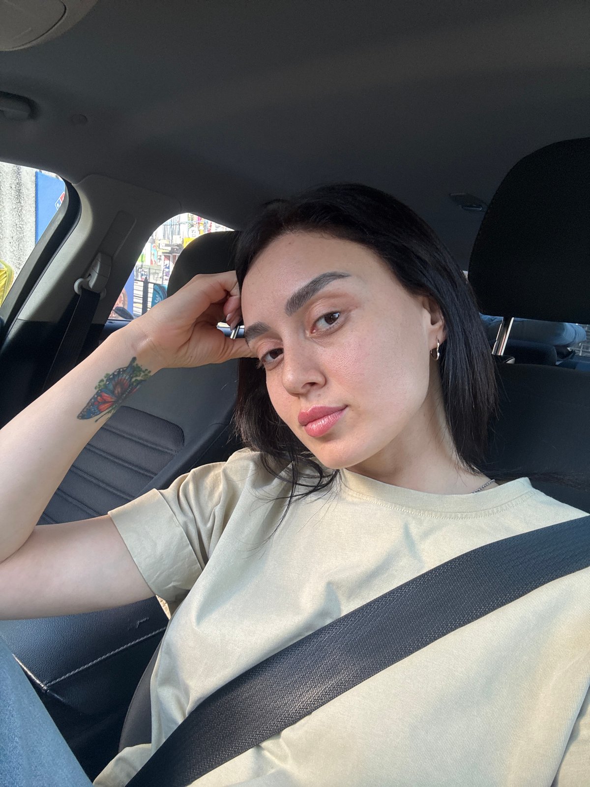 Woman with butterfly tattoo observed in parked car, Tbilisi