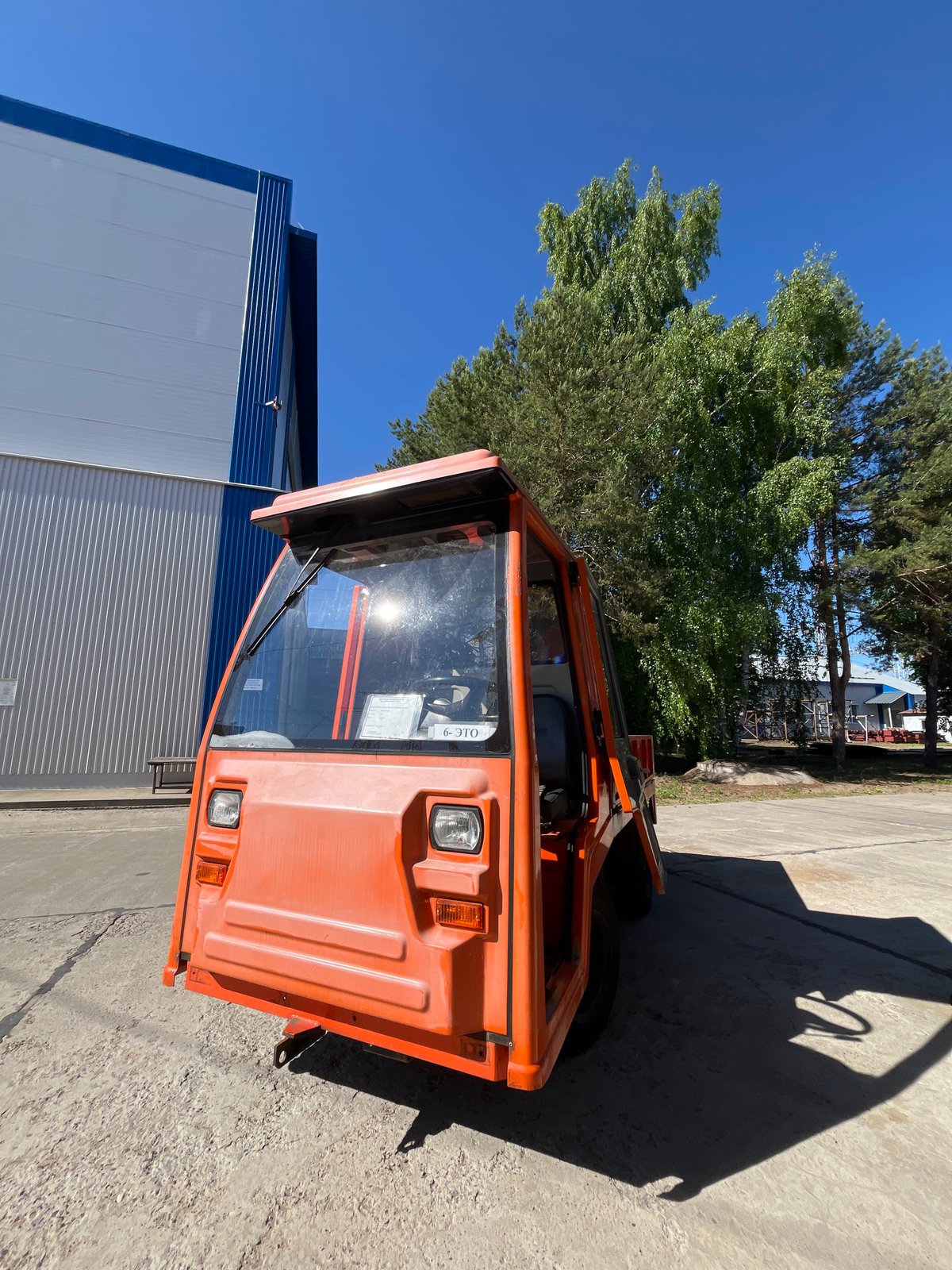 Orange utility vehicle parked outside building in Chaikovsky, Russia