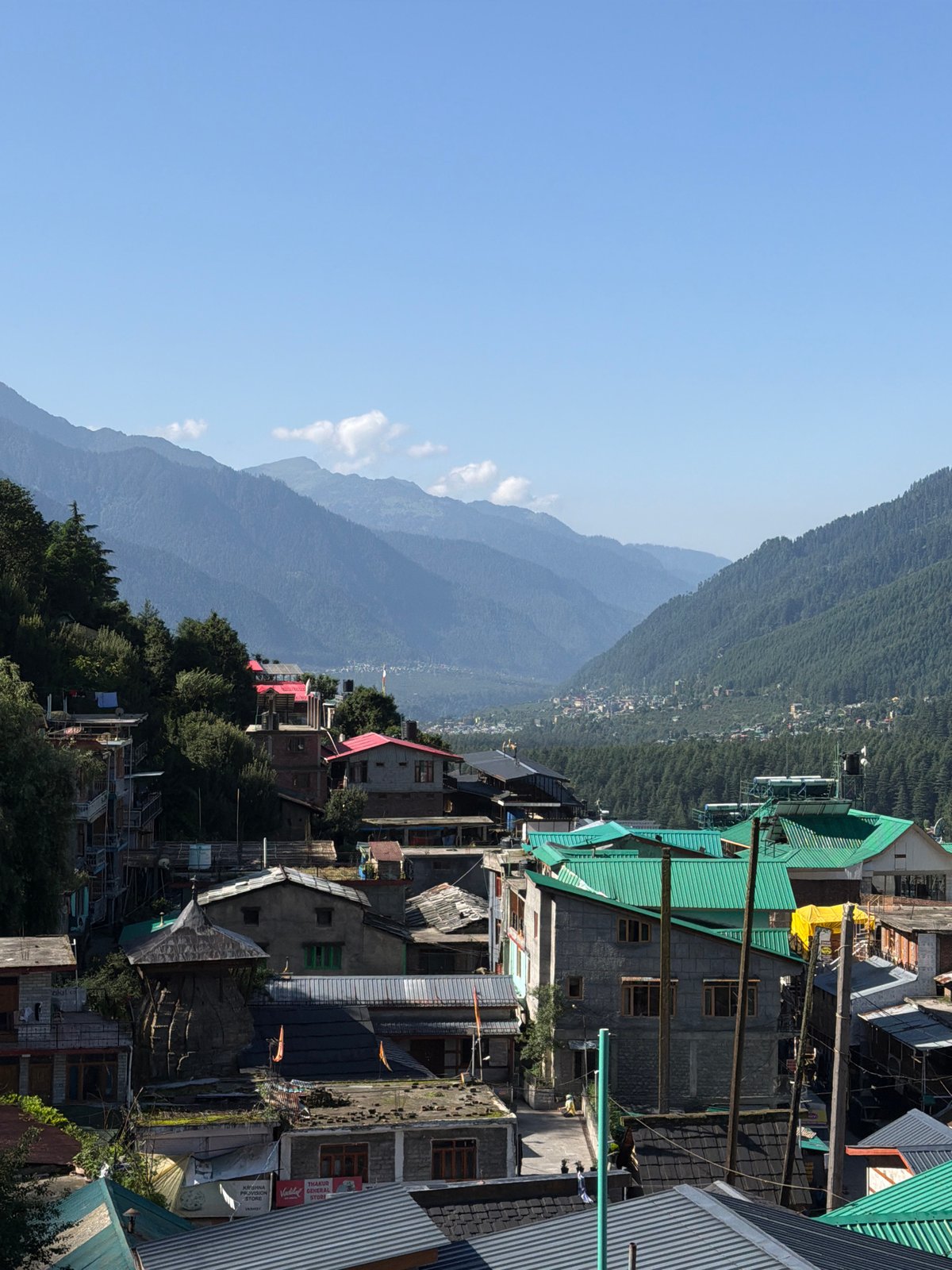 Bahang valley town seen from above, green hills and snowy peaks