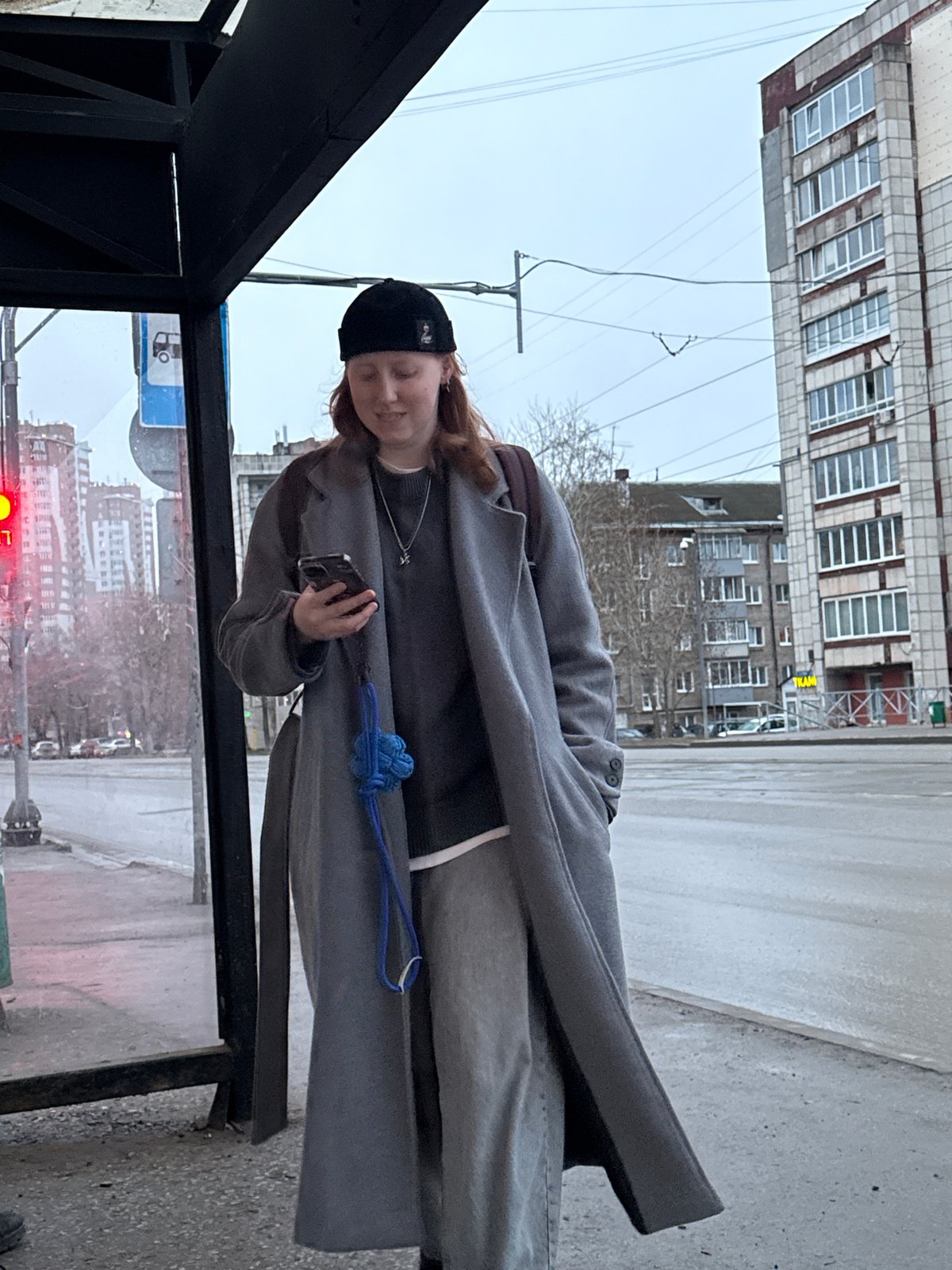 Person waits at bus stop in Perm during overcast afternoon
