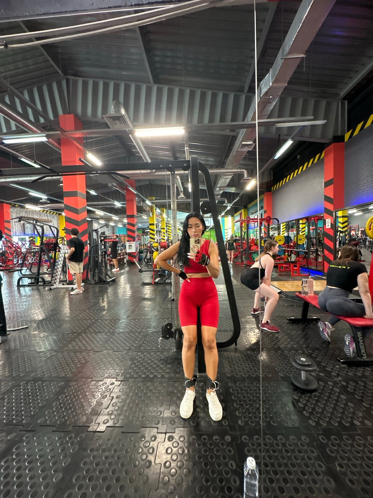 Mirror selfie at a Tyumen gym in red workout gear