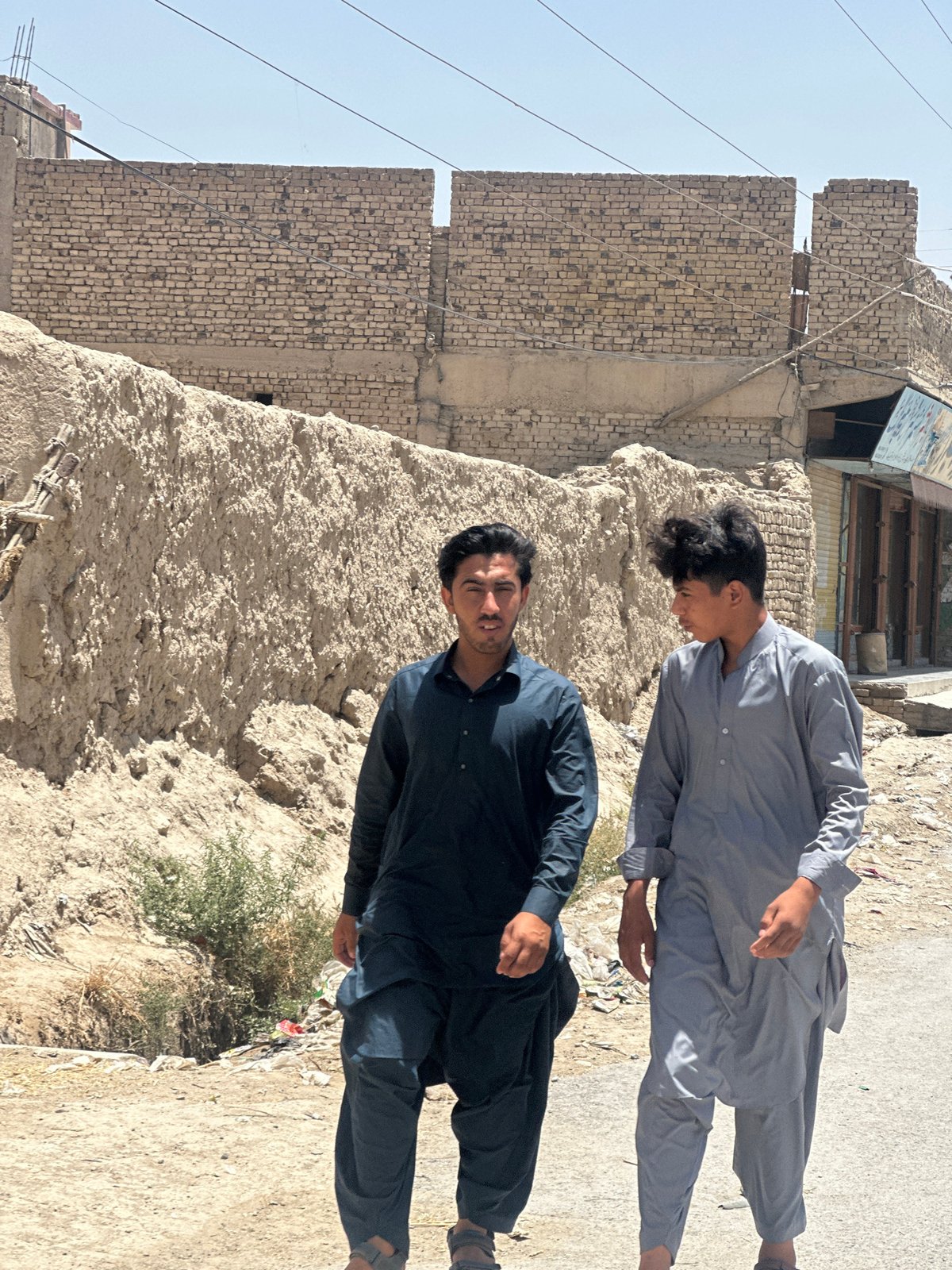 Two men photographed on dusty street in Quetta
