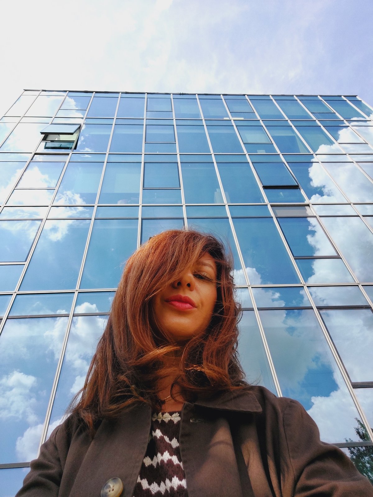 Selfies and storm clouds outside a glass building in Sofia