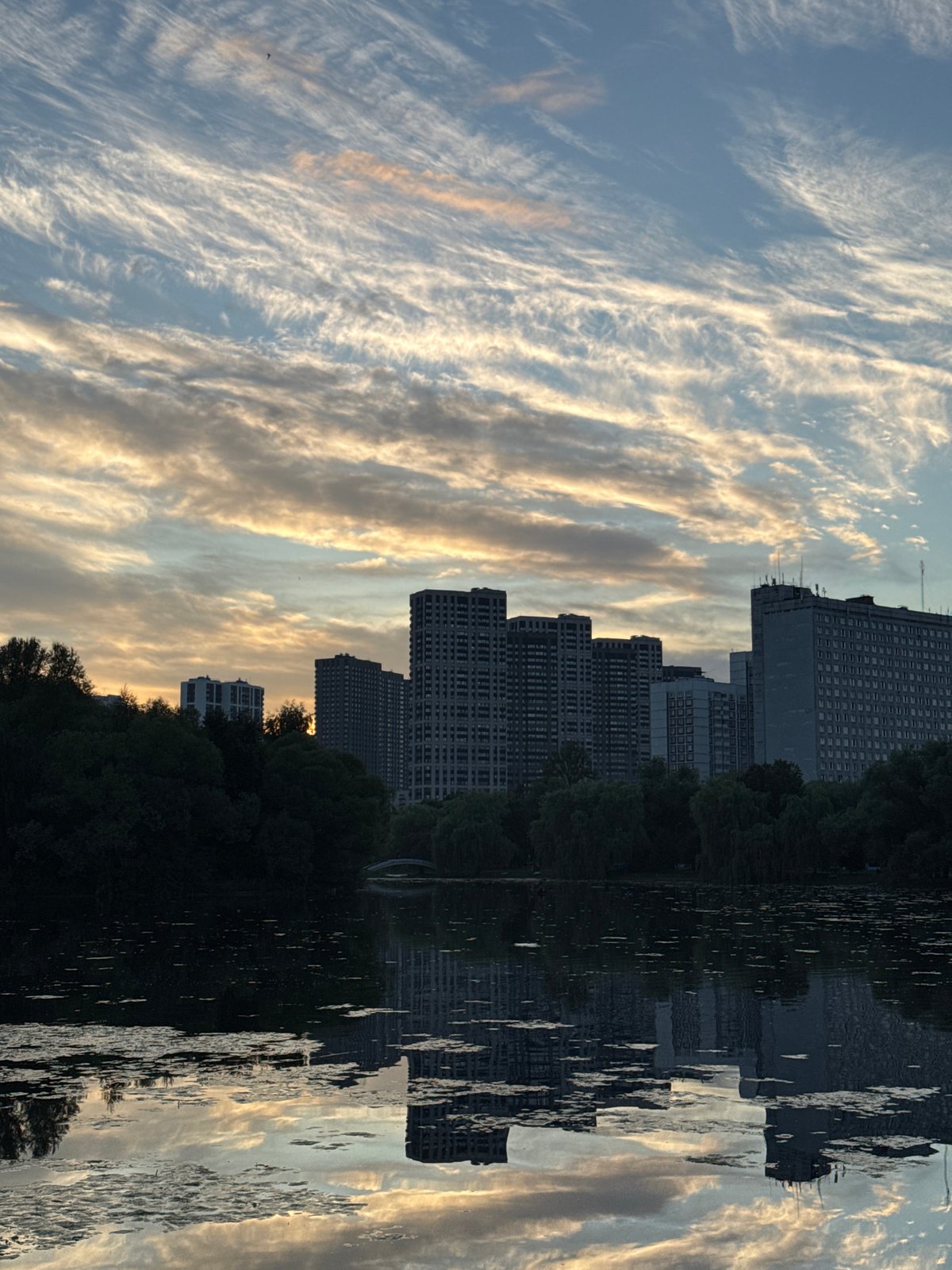 Moscow skyline mirrors across a calm lake at dusk