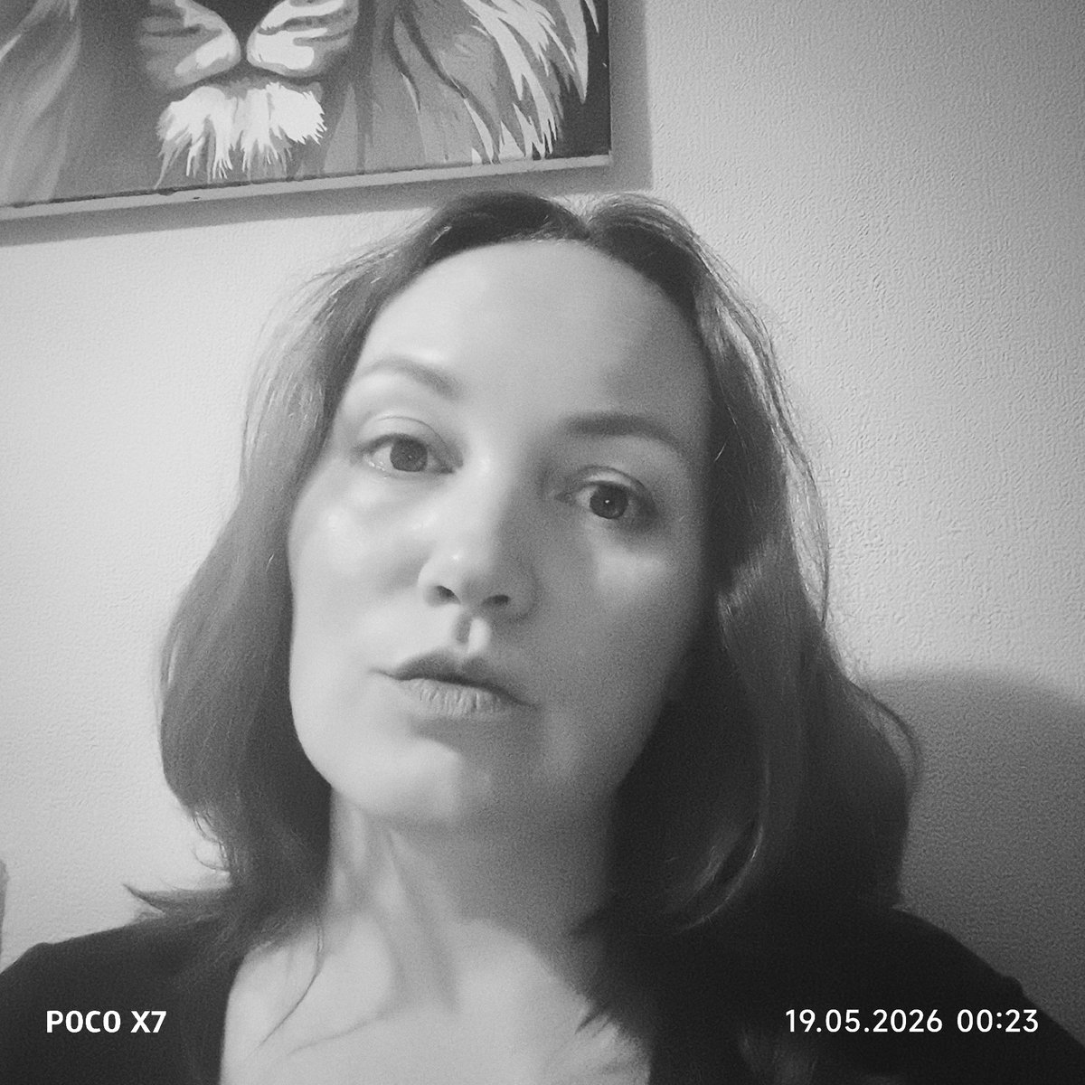 Woman takes black and white selfie against textured wall