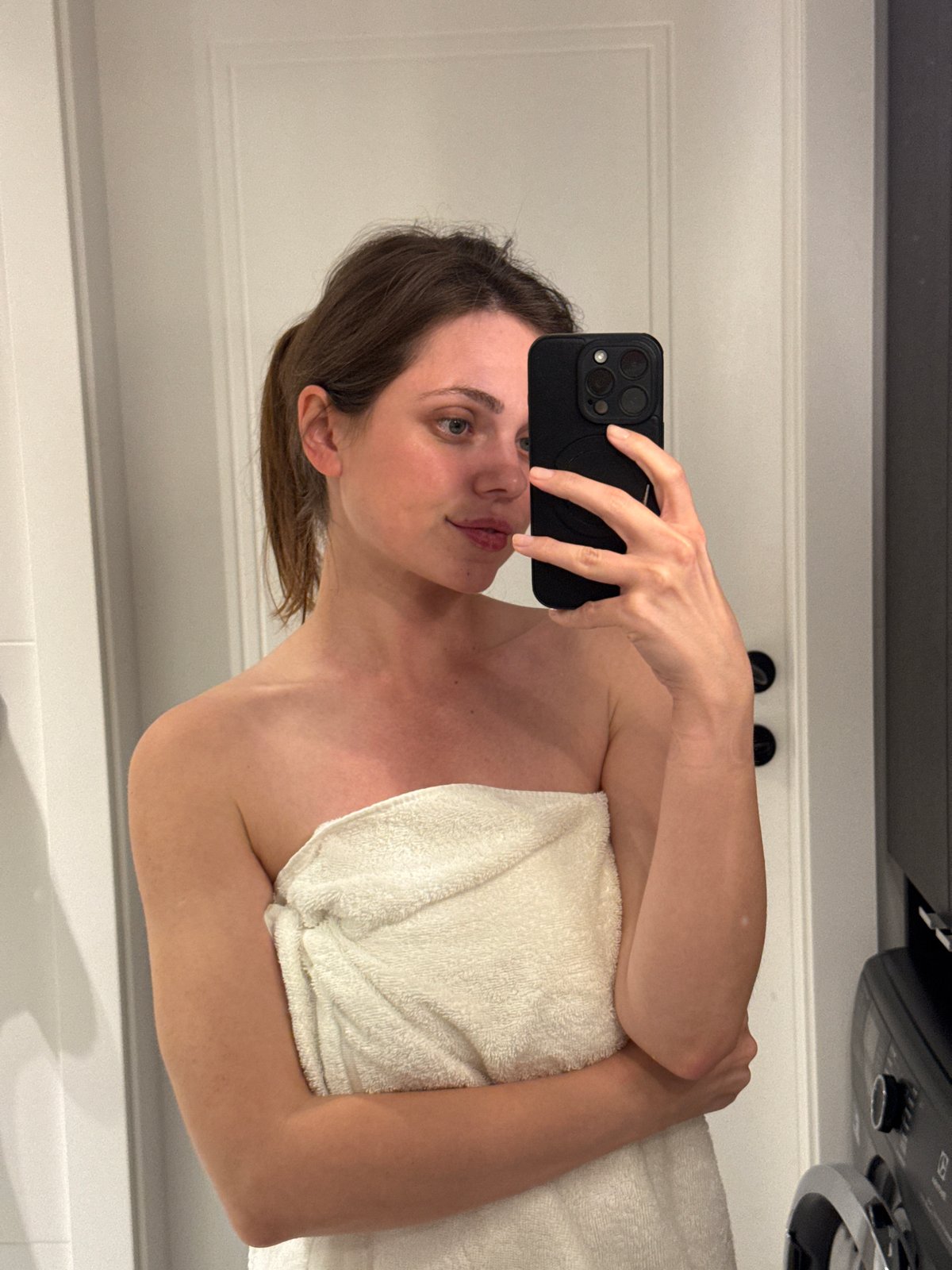 Bathroom mirror selfie in a modern tiled space
