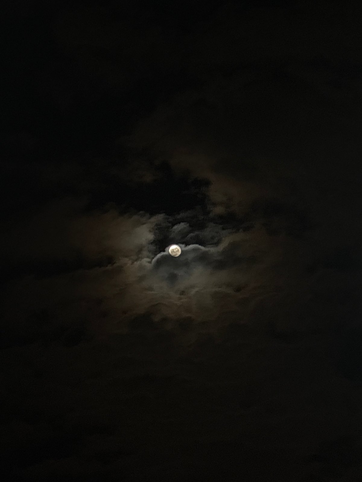 Full moon visible through clouds over Varna, Bulgaria
