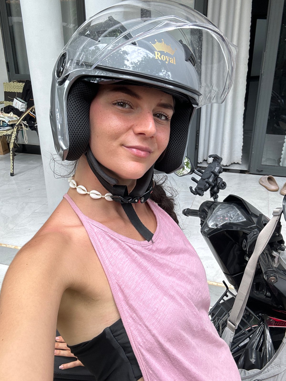 Woman in motorcycle helmet photographed smiling in Mũi Né