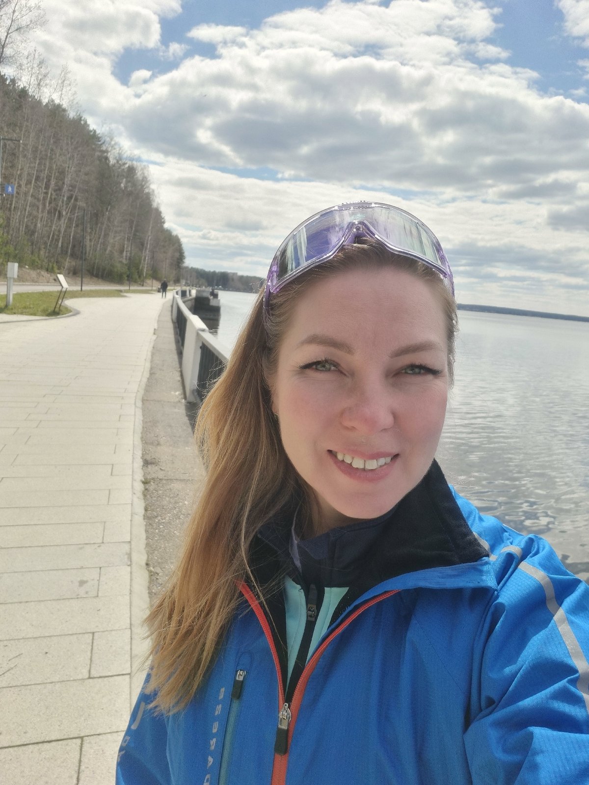 Woman photographs herself along Kama River embankment in Chaikovsky