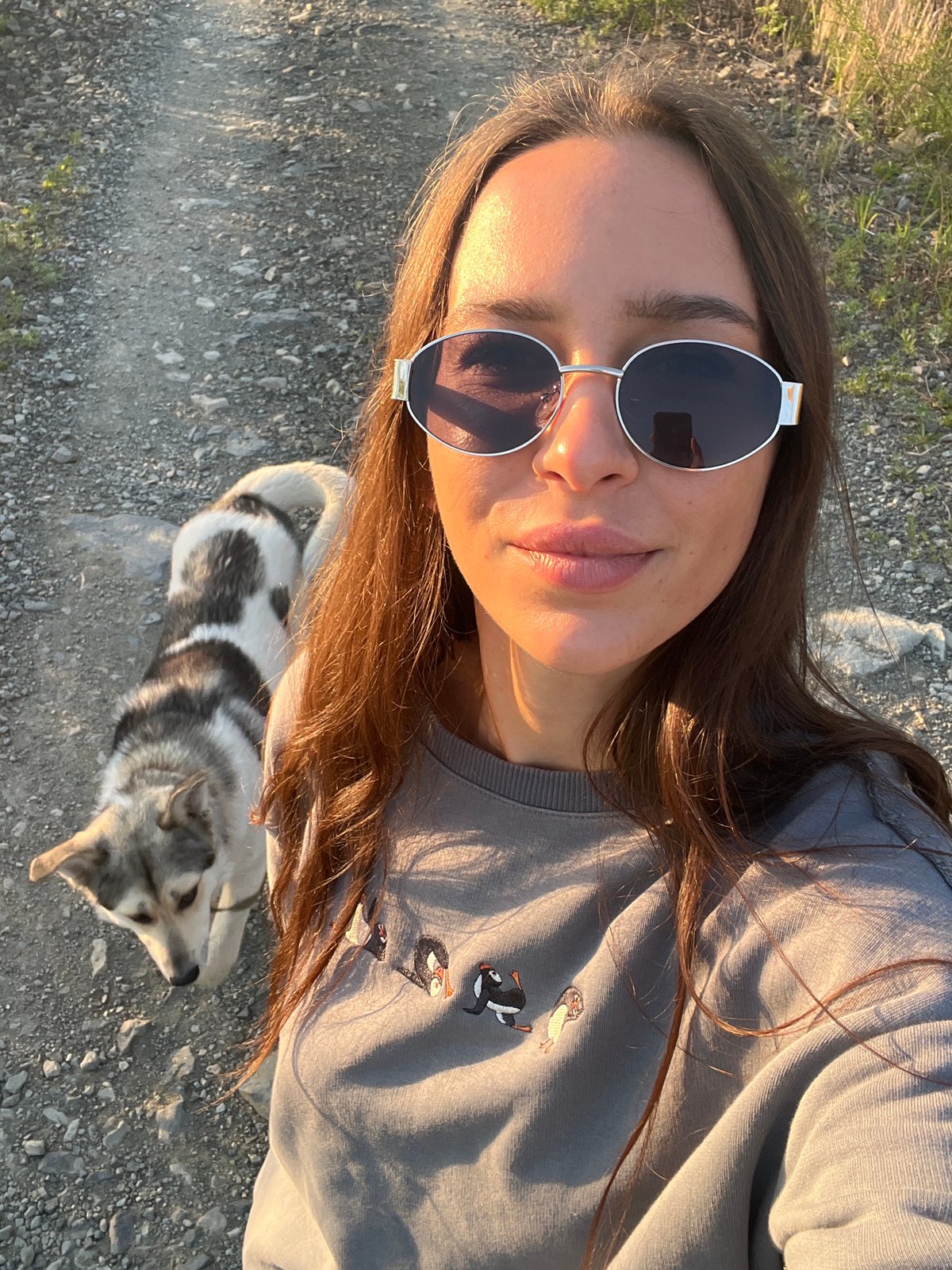 Woman walks dog on gravel road in Russian town