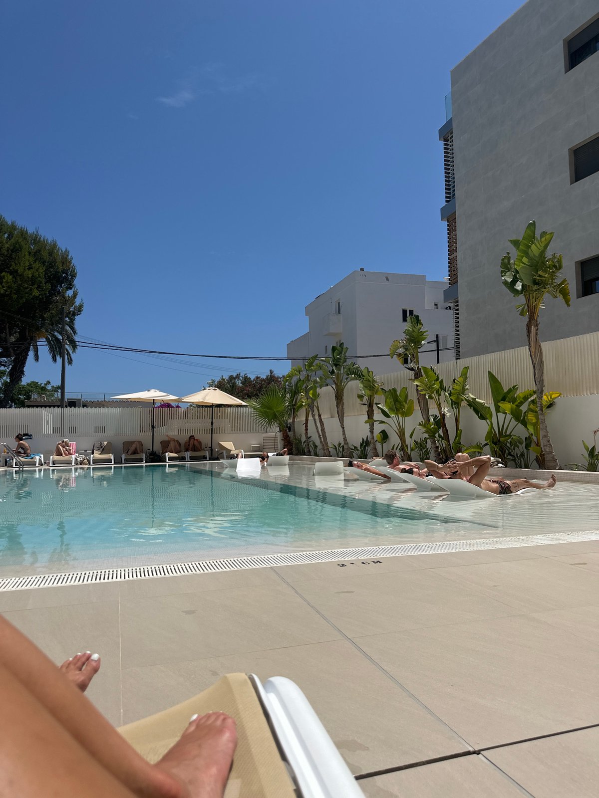 Resort guests enjoy poolside leisure time in Eivissa