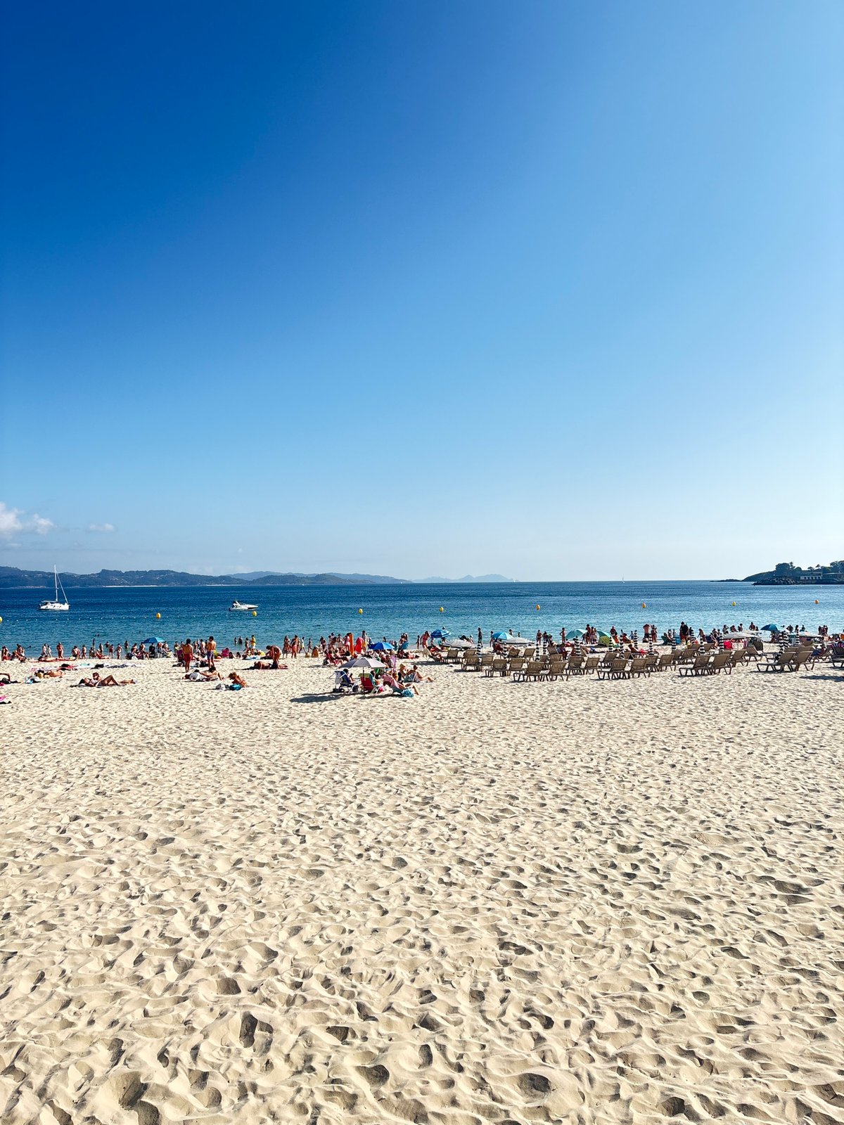 Sanxenxo beach and harbor on a busy summer afternoon