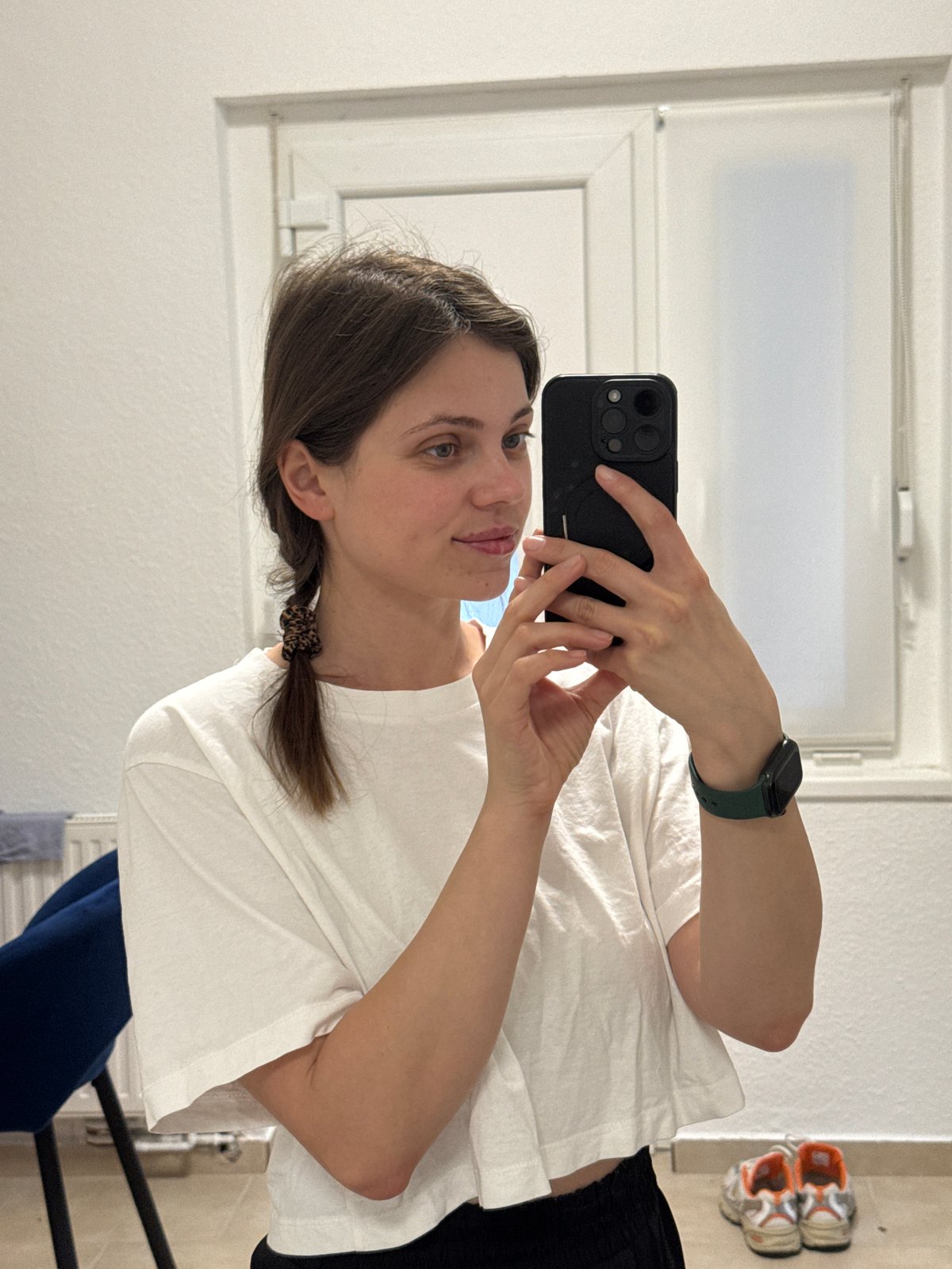 Woman takes bathroom mirror selfie in Kőröshegy, Hungary