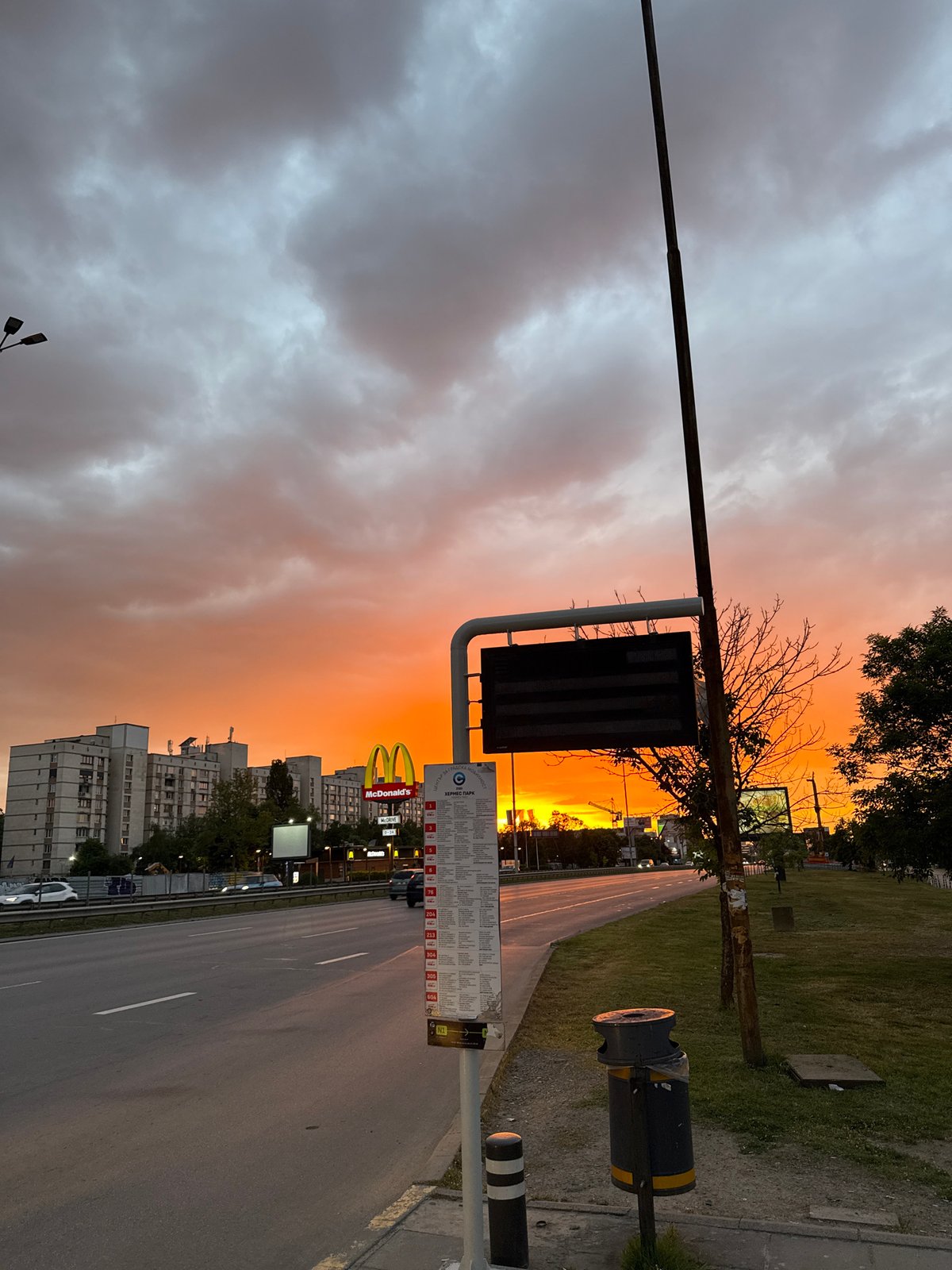Sunset observed over Sofia street scene with McDonald's, parking