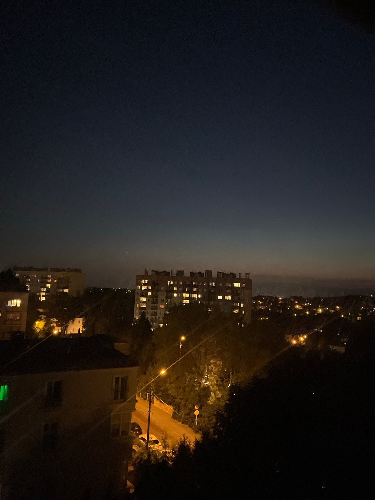 City skyline at dusk, shot from above as lights come on