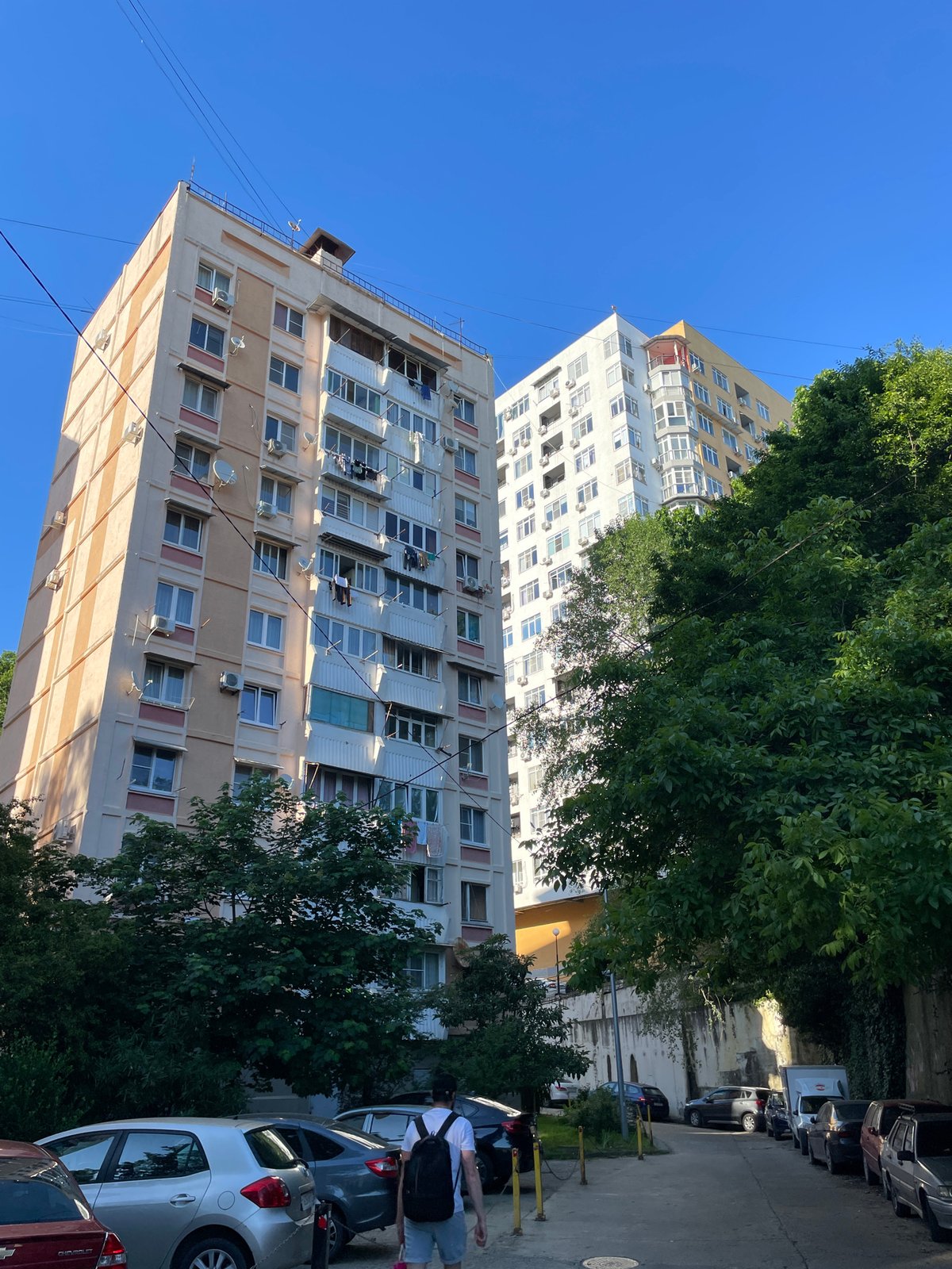Pedestrian documents residential Sochi neighborhoods in afternoon walkabout