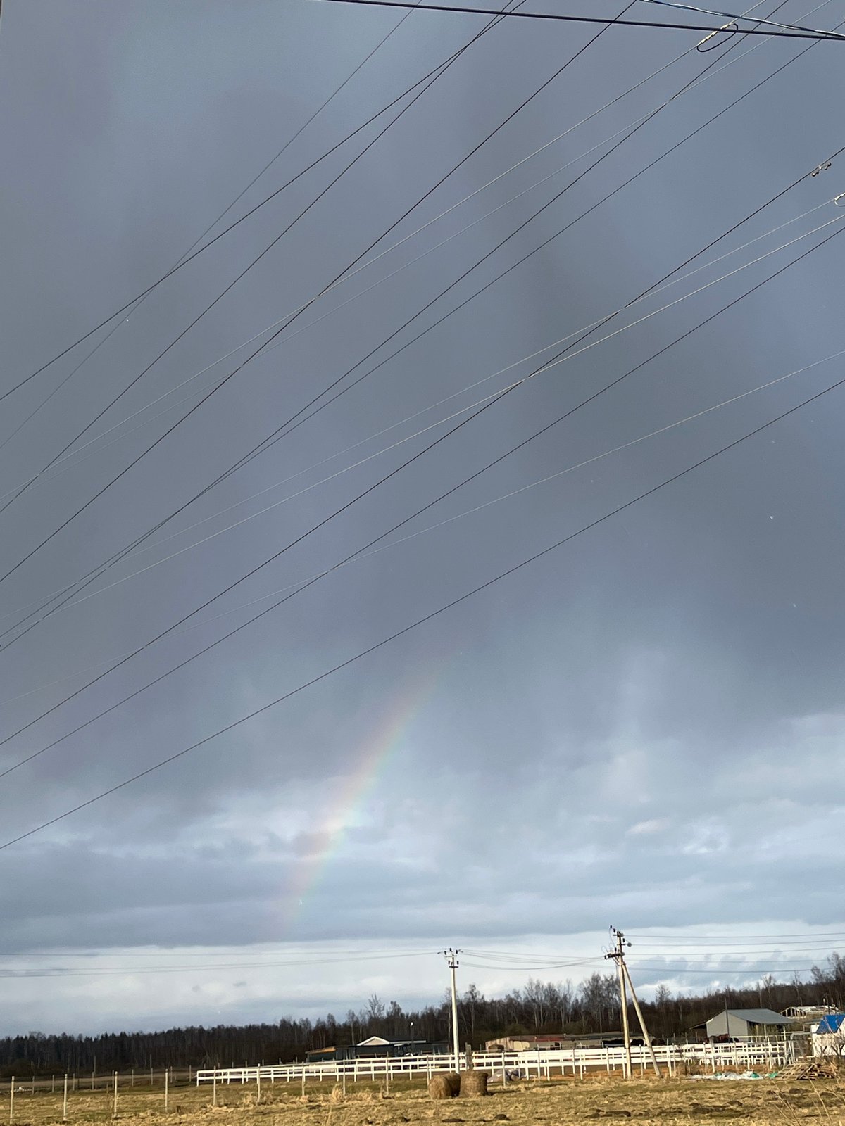 Faint rainbow appears over power lines in Razdol'e, Russia