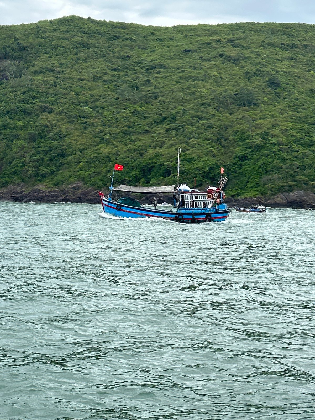 Fishing boats and tourist vessels share choppy Nha Trang coastal waters