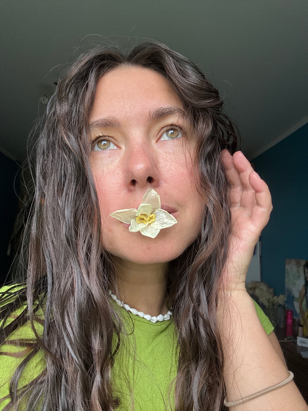 Woman poses with dried flower against wall in Kazan