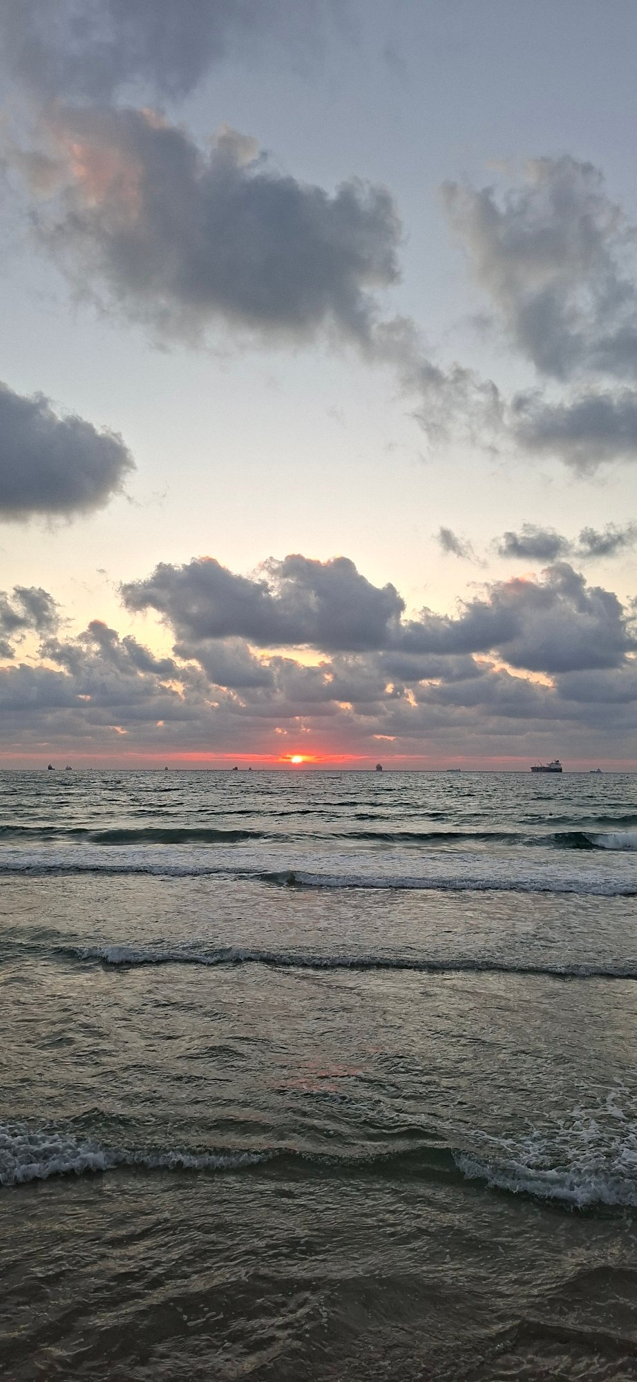 Sunset at the waterfront: waves, fishing rods, and fading light