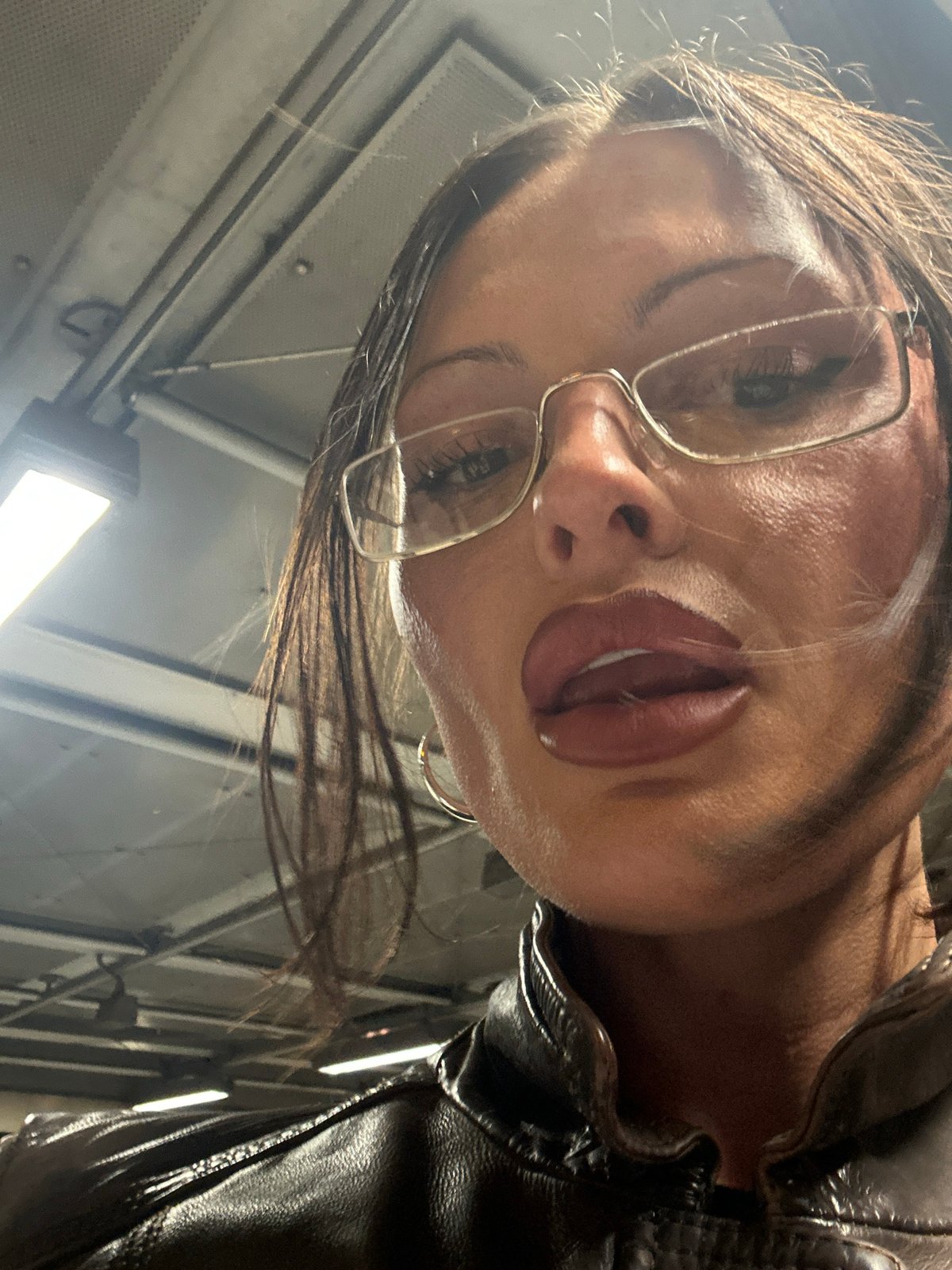 Portrait of glasses-wearing person in leather jacket captured in London