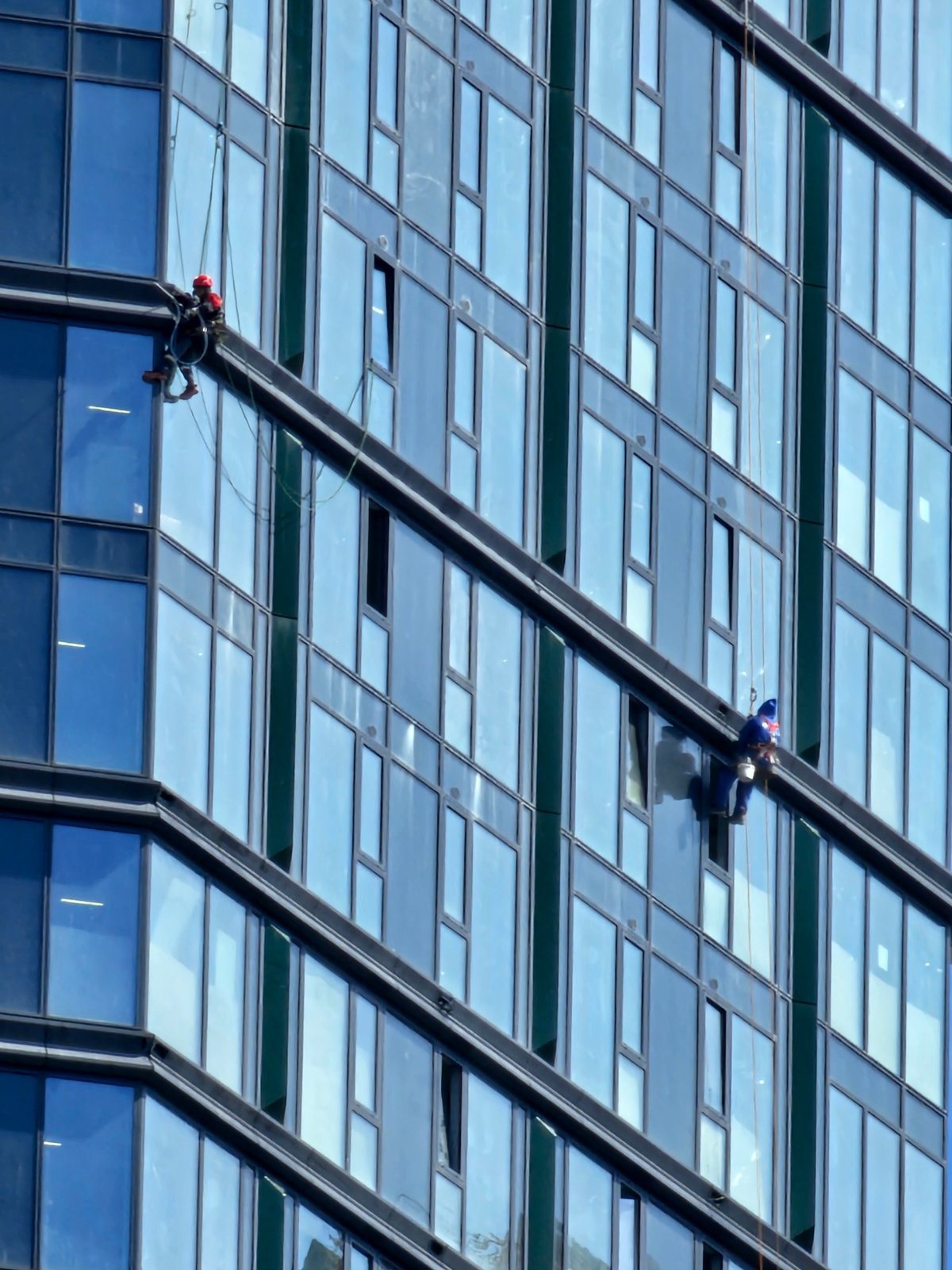 Crews service the glass facade of a Moscow high-rise