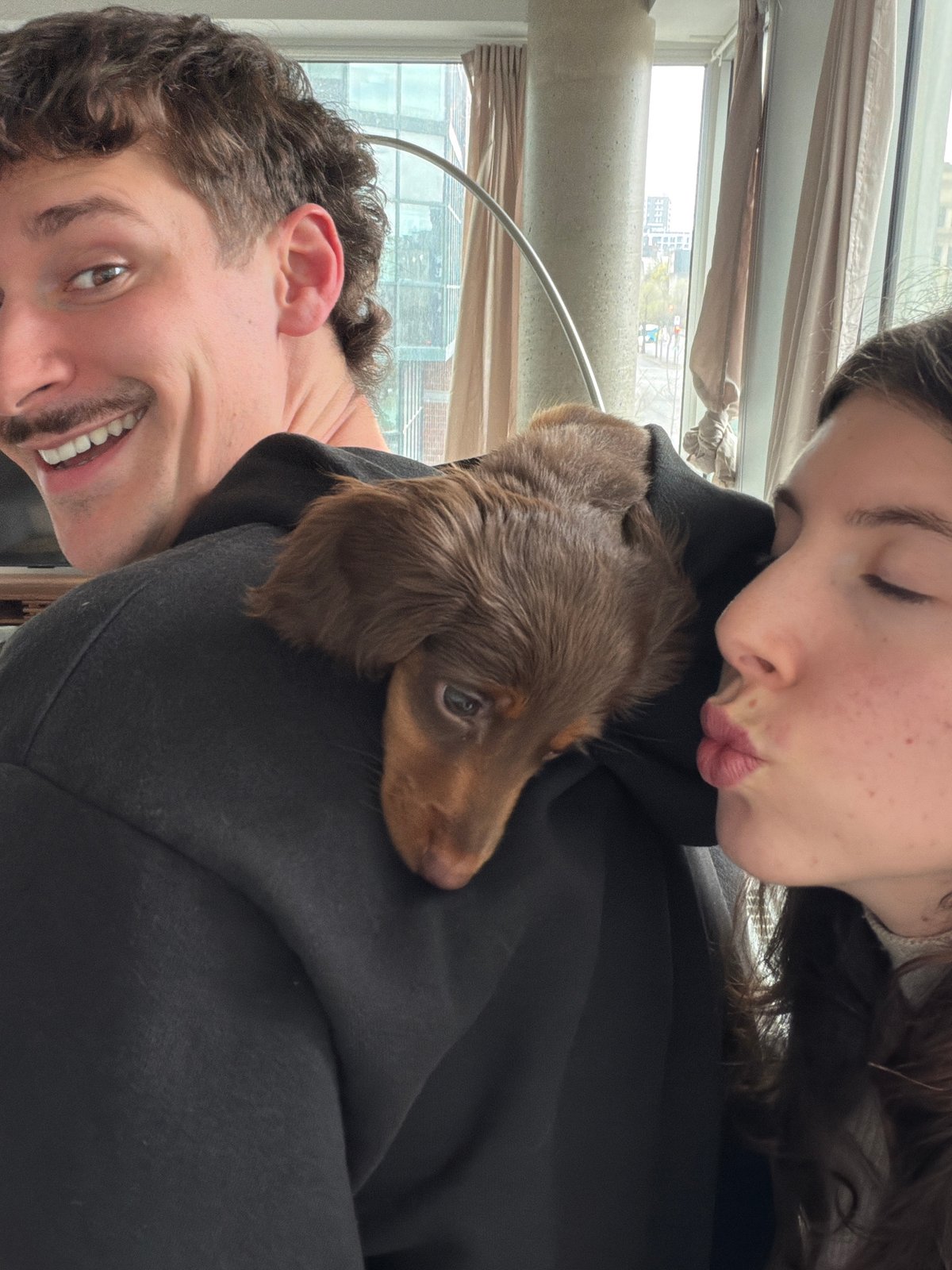Couple takes selfies with dachshund puppy in Montreal apartment