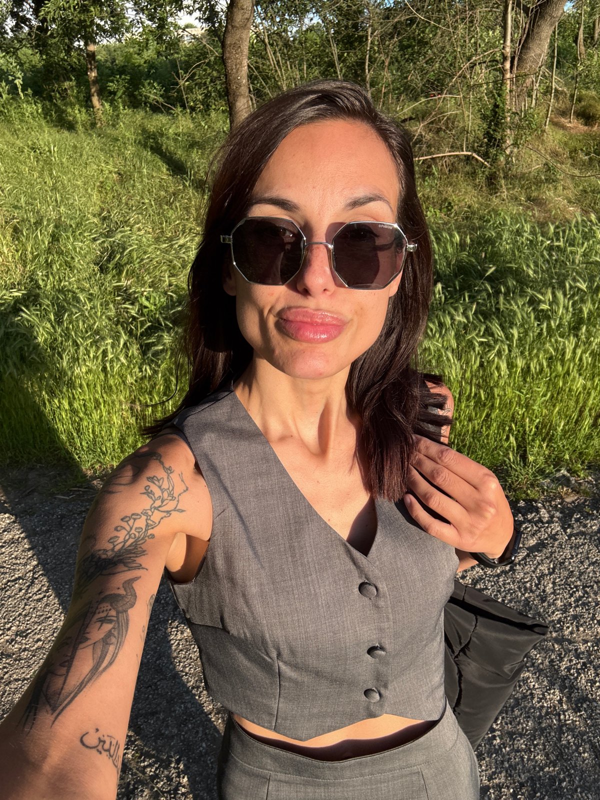 Tattooed woman in gray vest spotted outdoors, elevator in Pleven