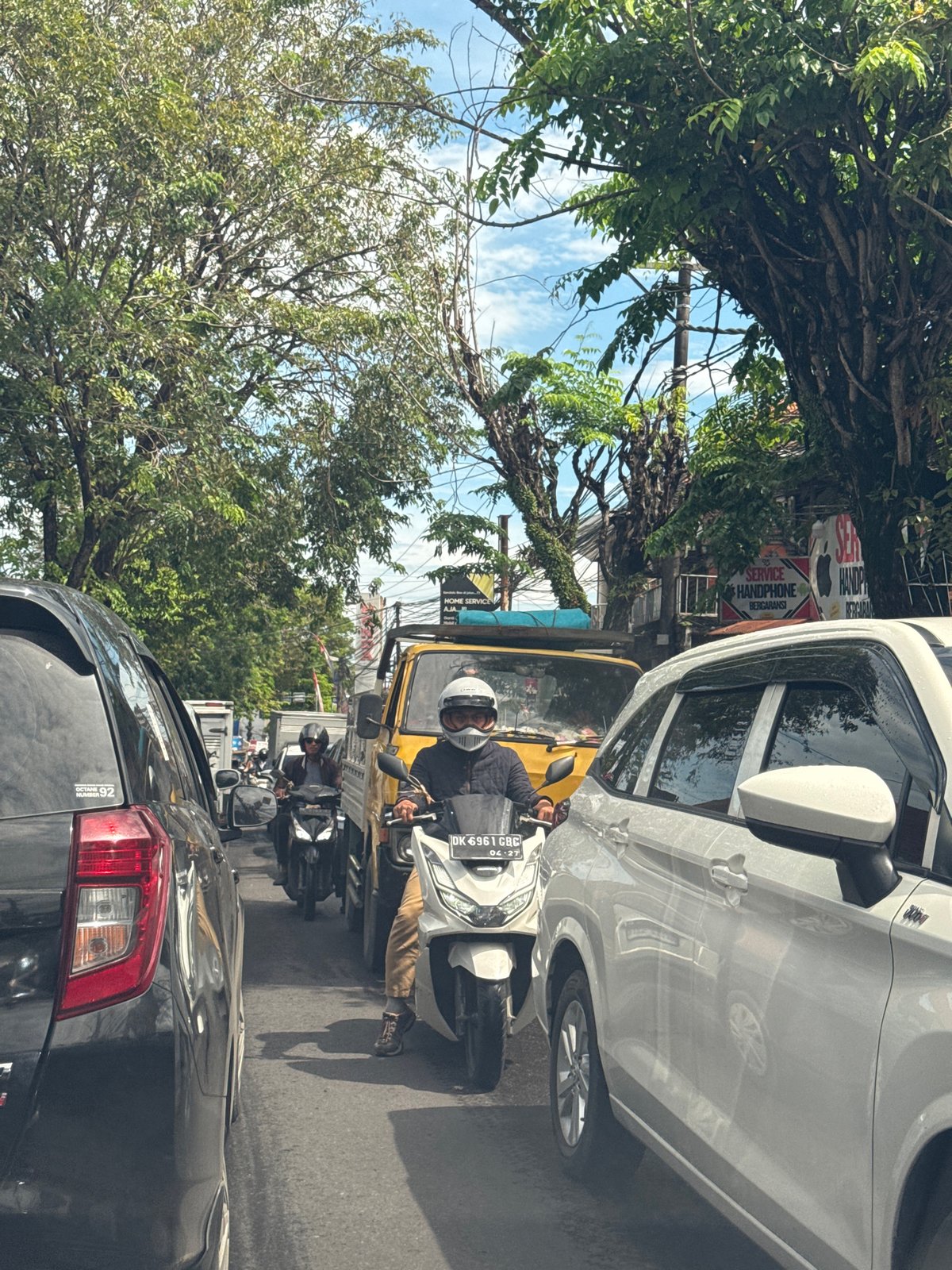 Rainy day scooter traffic documented in North Kuta streets