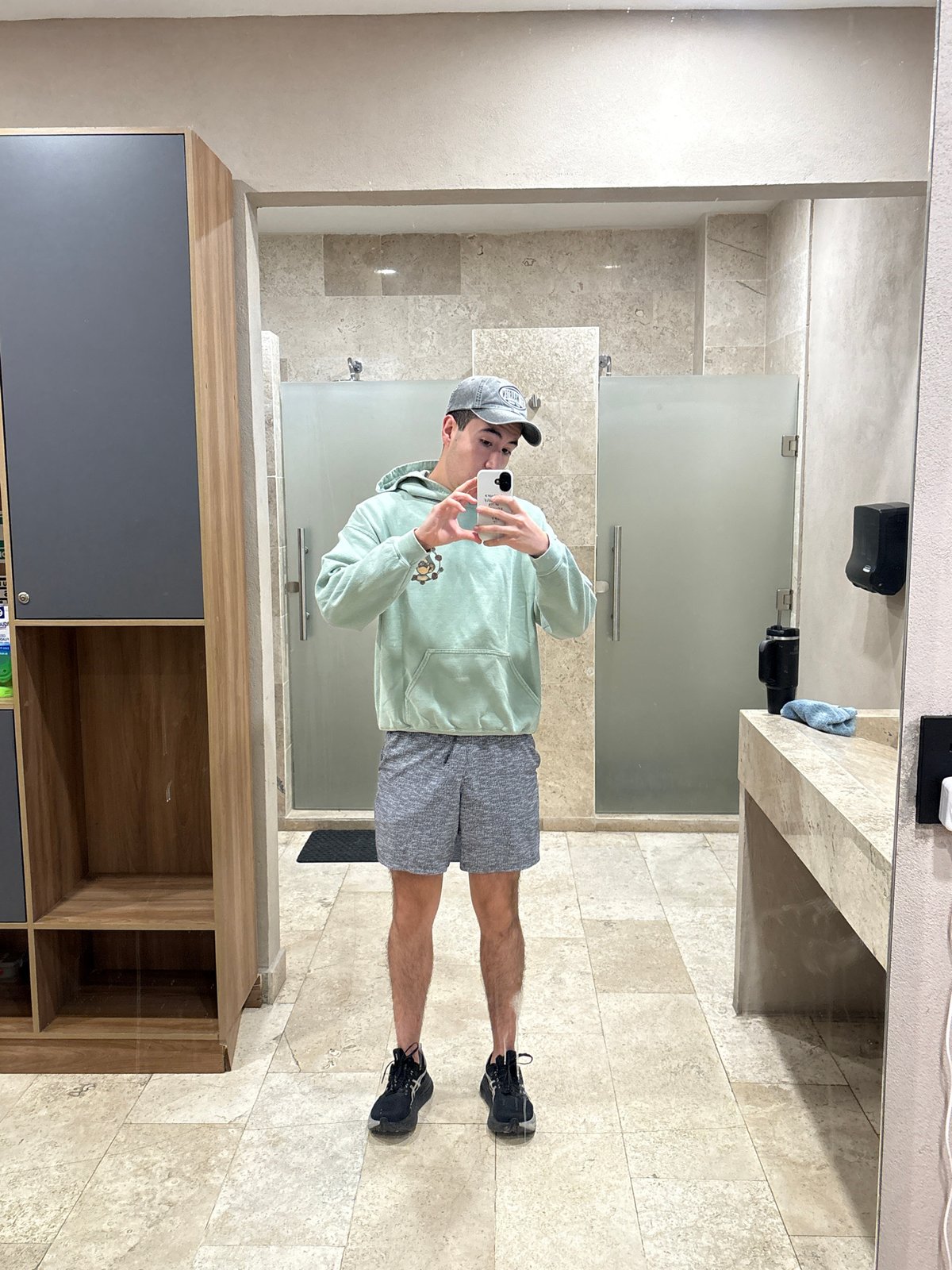 Mirror selfie in a Puebla restroom, mint green hoodie