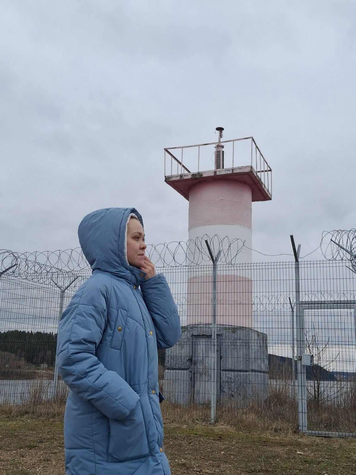 Person photographed at striped lighthouse in Chaikovsky, Russia