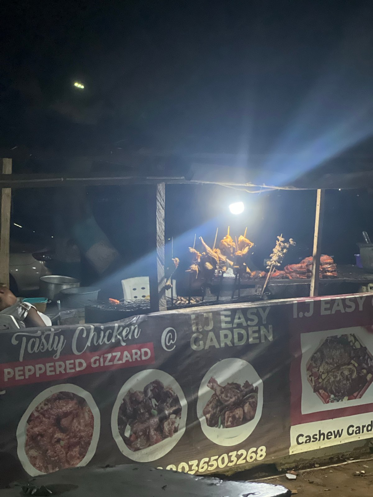 Street food vendor prepares grilled chicken sandwiches in Abuja