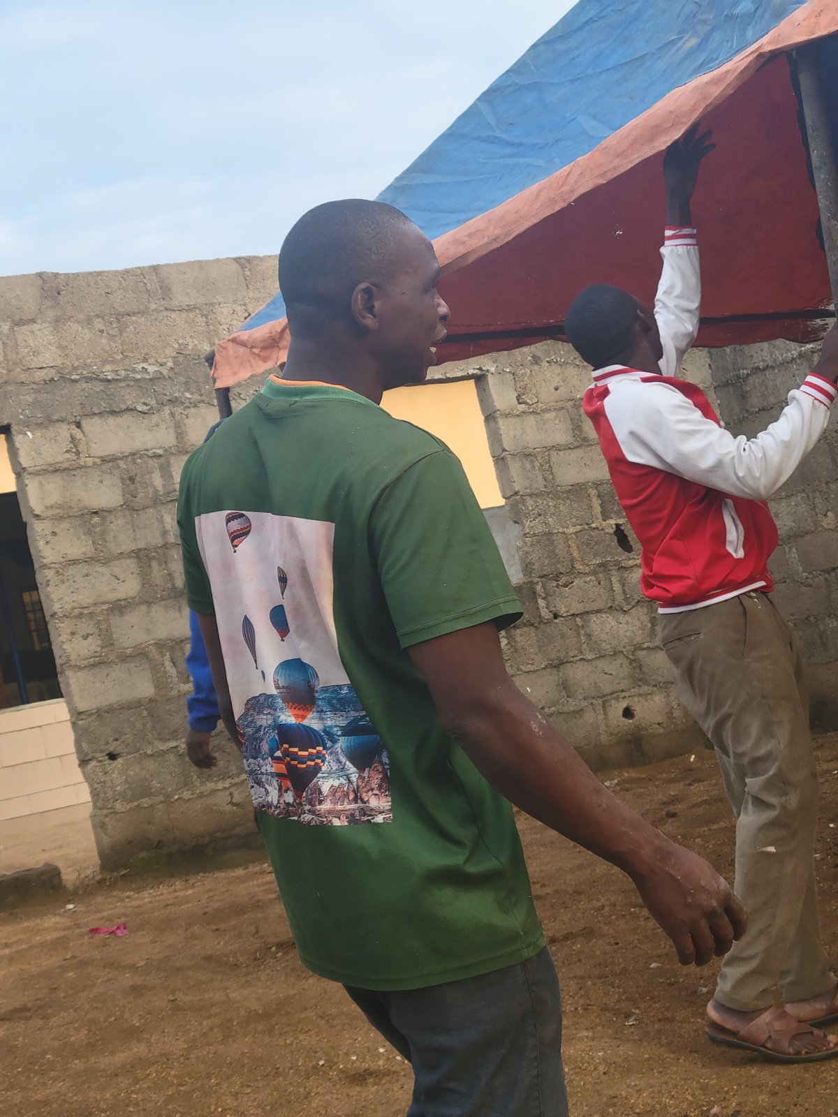 Construction site activity and tarp setup in Madalla, Nigeria
