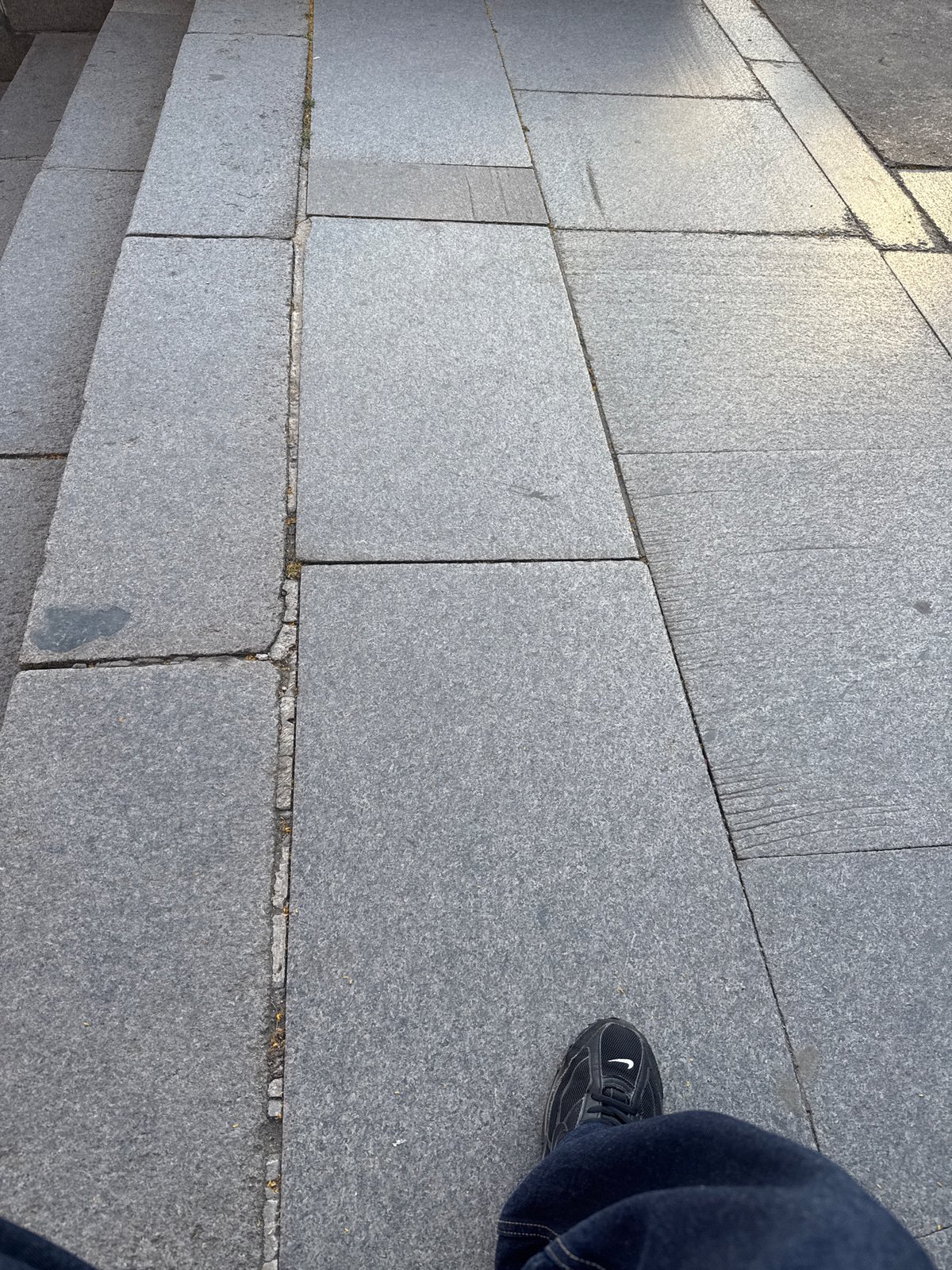 Person documents walk on granite sidewalks in Sofia