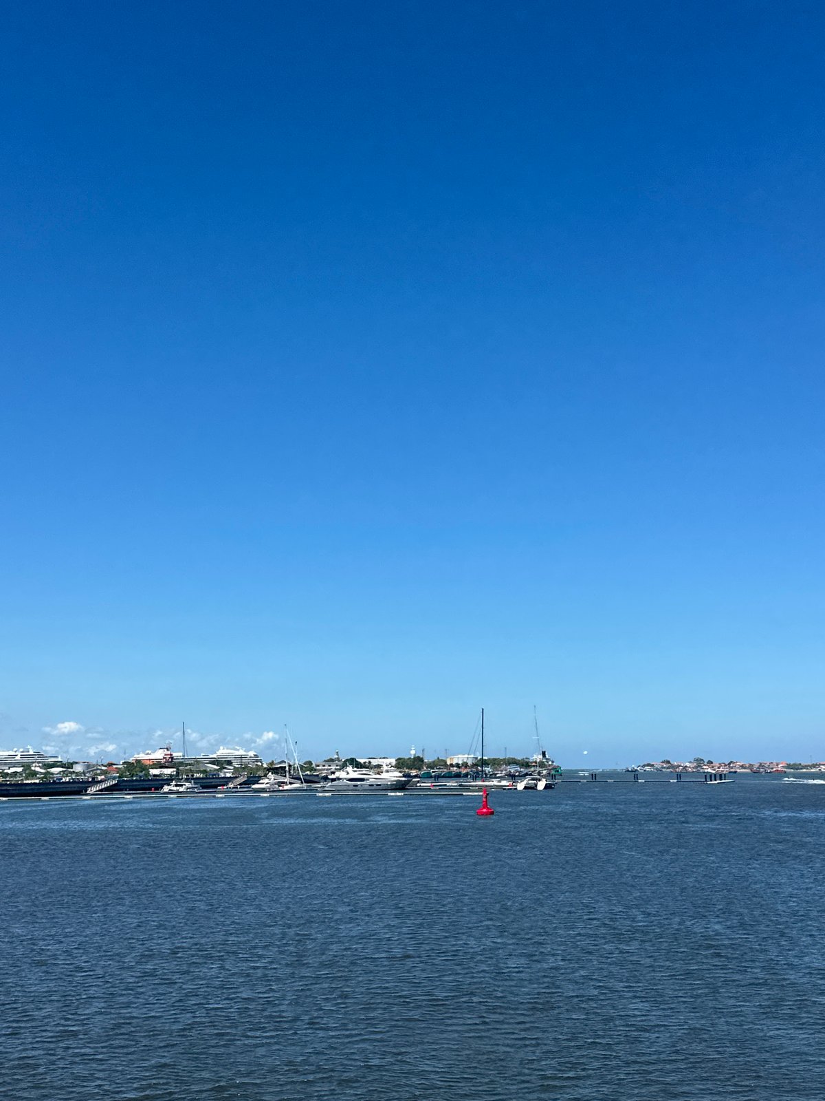 Motorcycle rider documents sunny waterfront journey through Denpasar-Kuta area