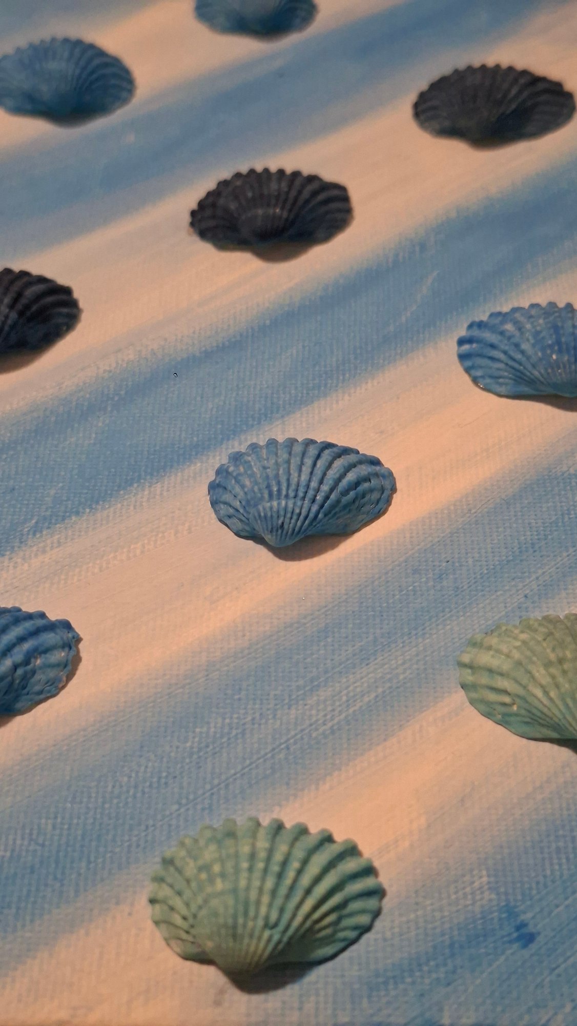 Seashell art in progress on striped canvas, Podgorica