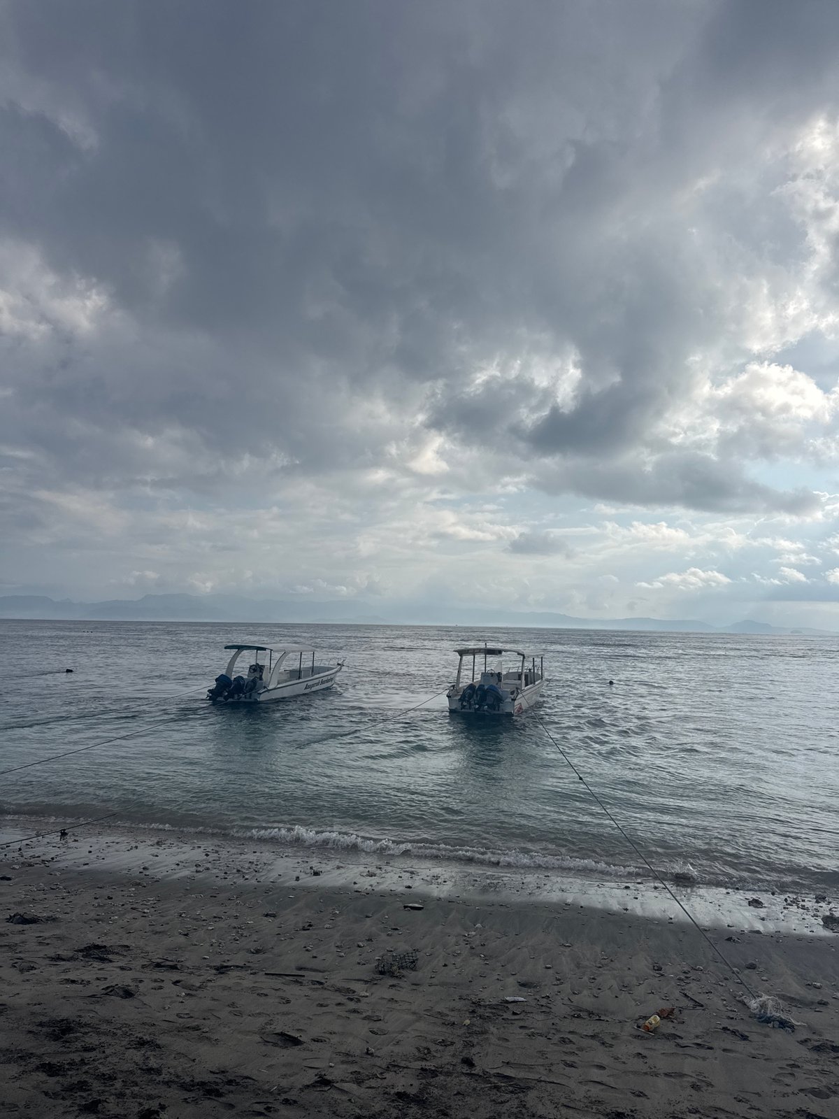 Dark sand, speedboats, and beach life on Nusa Penida