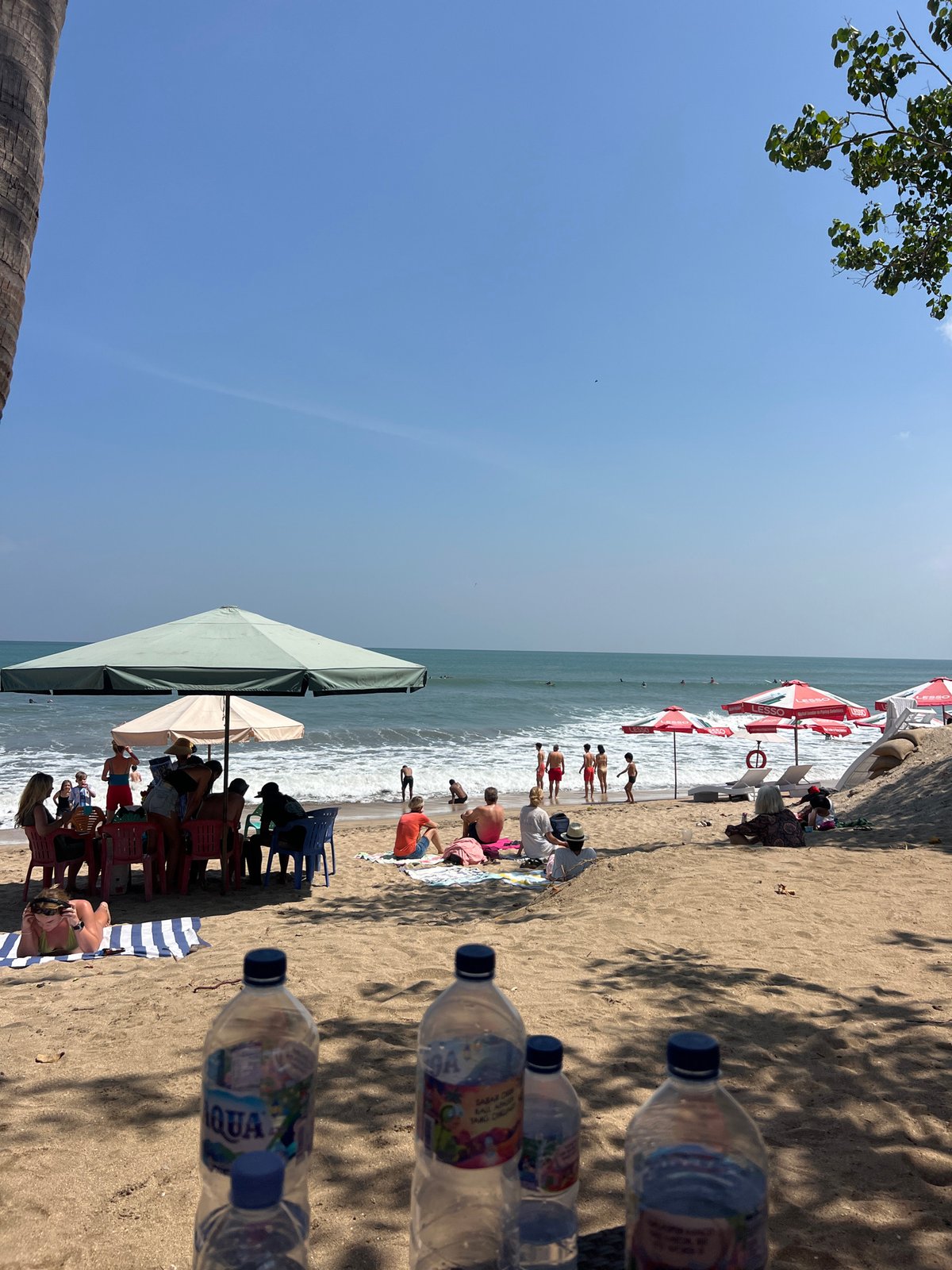 Busy morning at Kuta Beach — surfers, sunbathers, and shore life