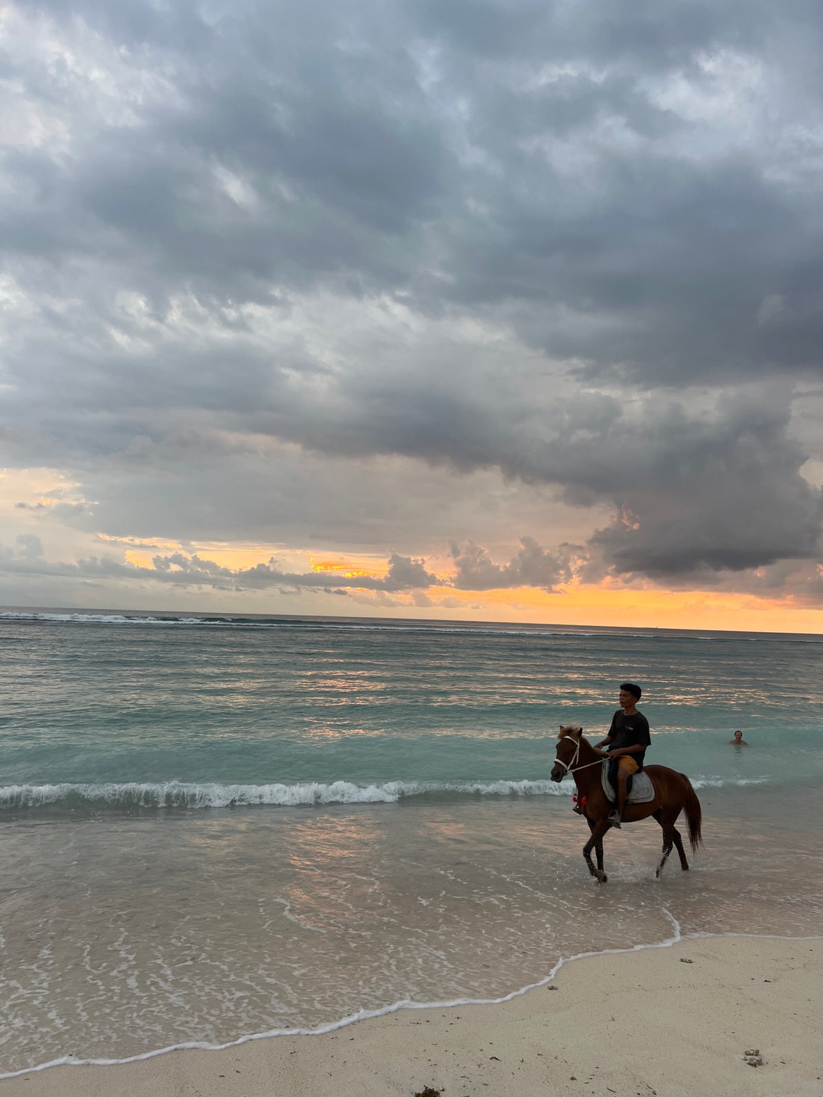 Horse rider spotted on Indonesian beach under cloudy skies