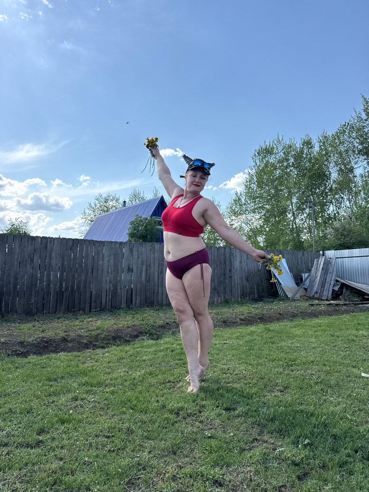 Woman with goggles poses with dandelions in Chaikovsky, Russia