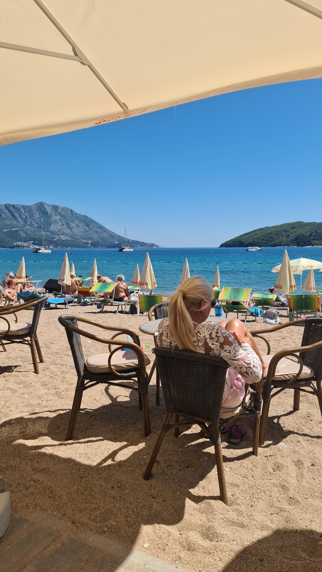Woman enjoys beachside cafe moment in Budva, Montenegro