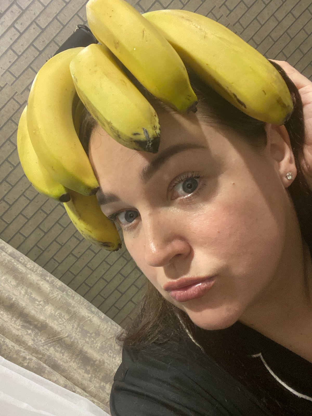 Woman poses with bananas in playful indoor photo session