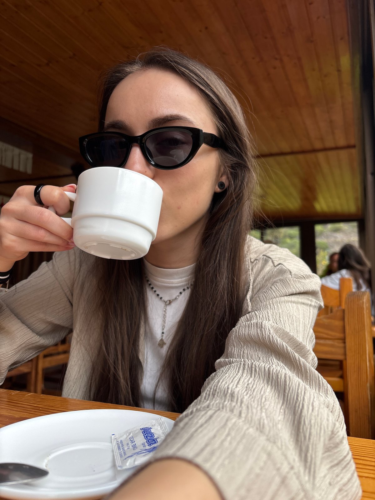 Woman enjoys morning coffee with mountain views in Spanish café