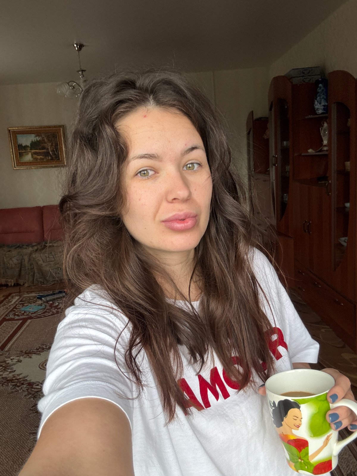 Woman drinks coffee indoors during heavy rainstorm in rural Russia