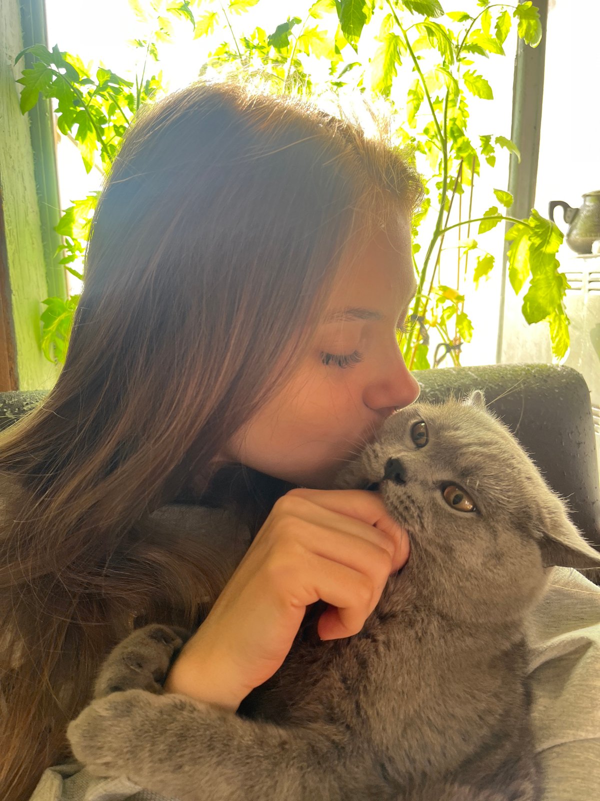 Woman and gray cat share tender moments in Russian village