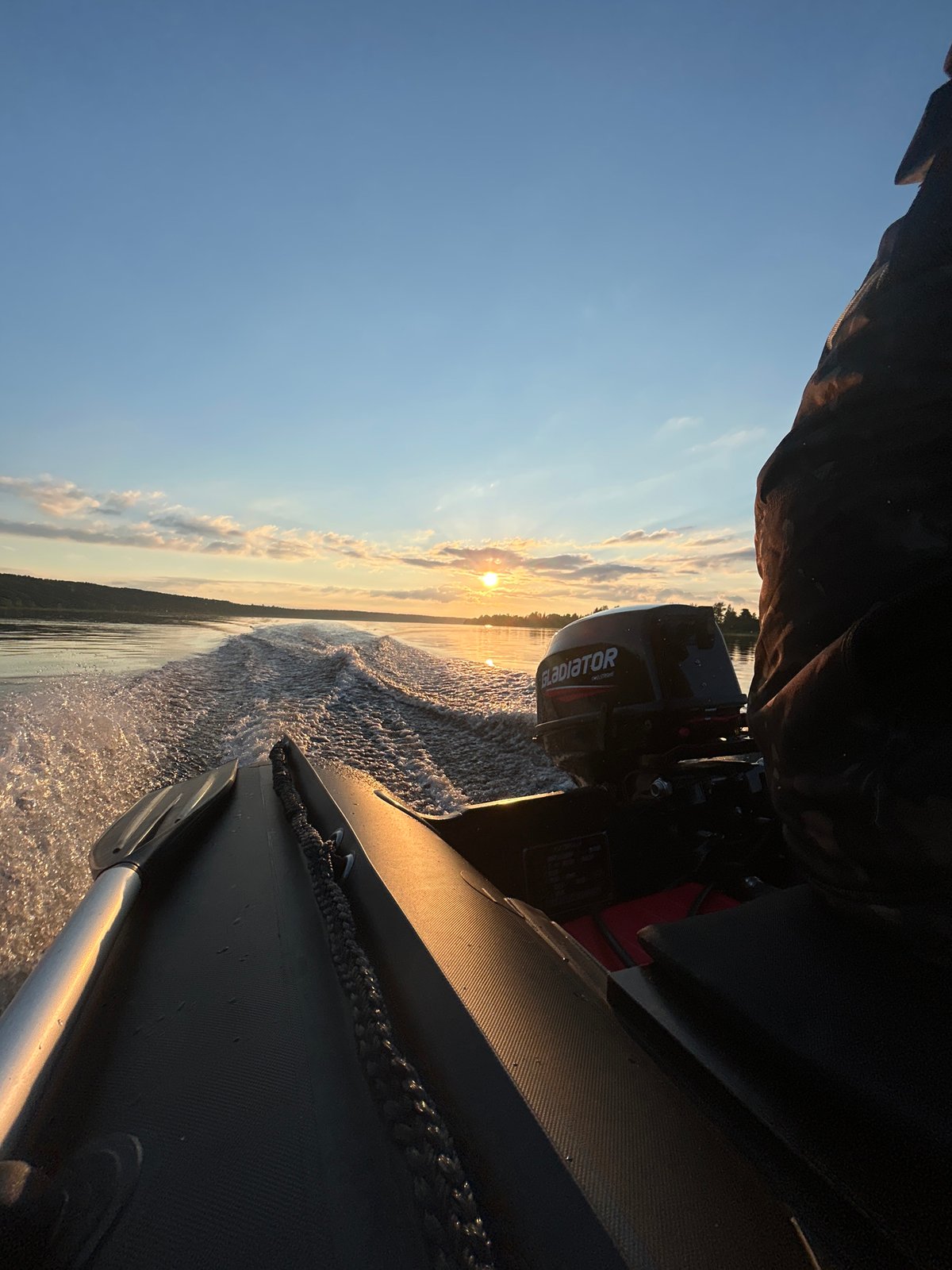 Fishing boat cruises calm Russian waters at golden hour