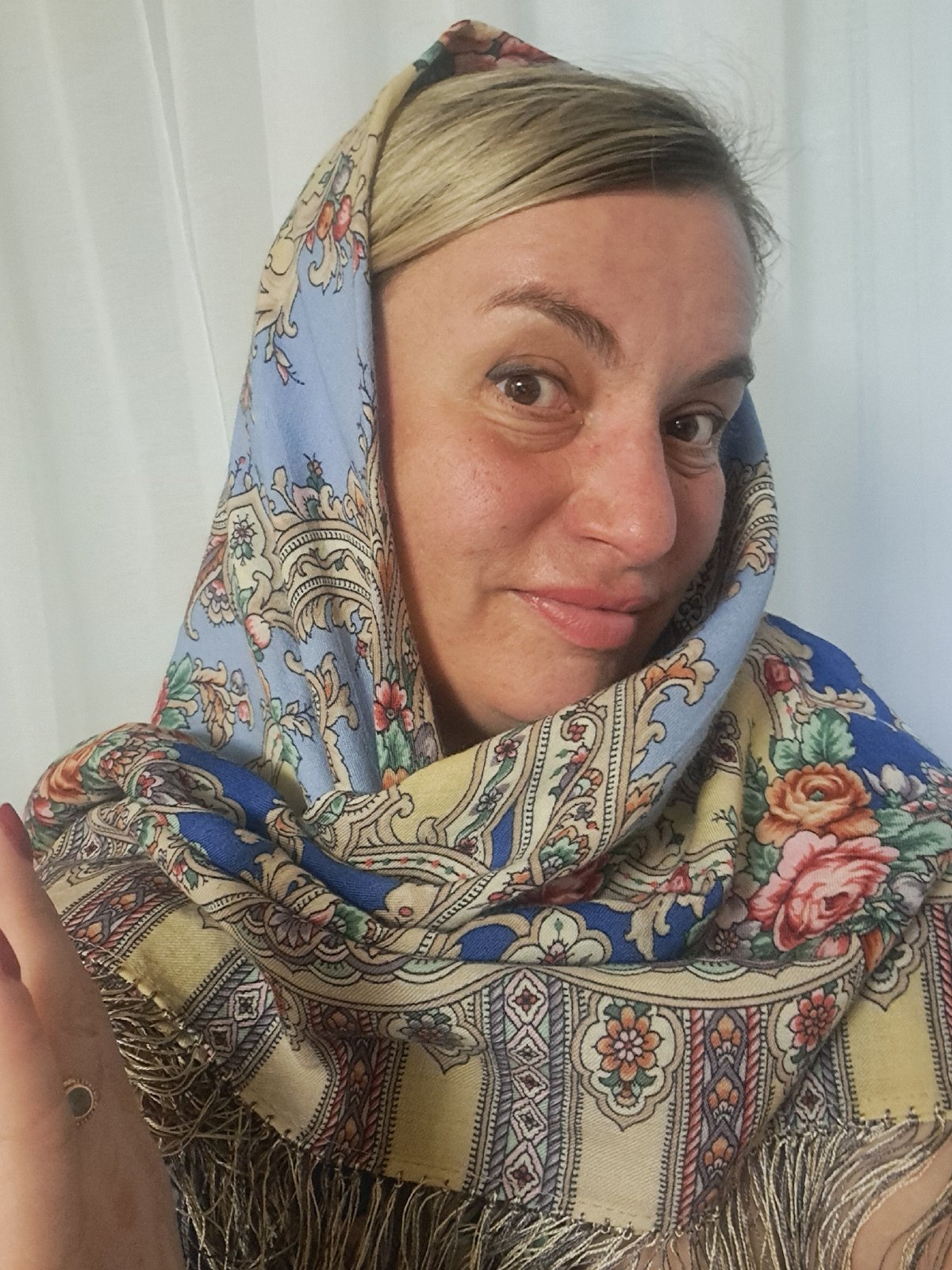 Woman displays floral scarves, cats rest in Elektrostal