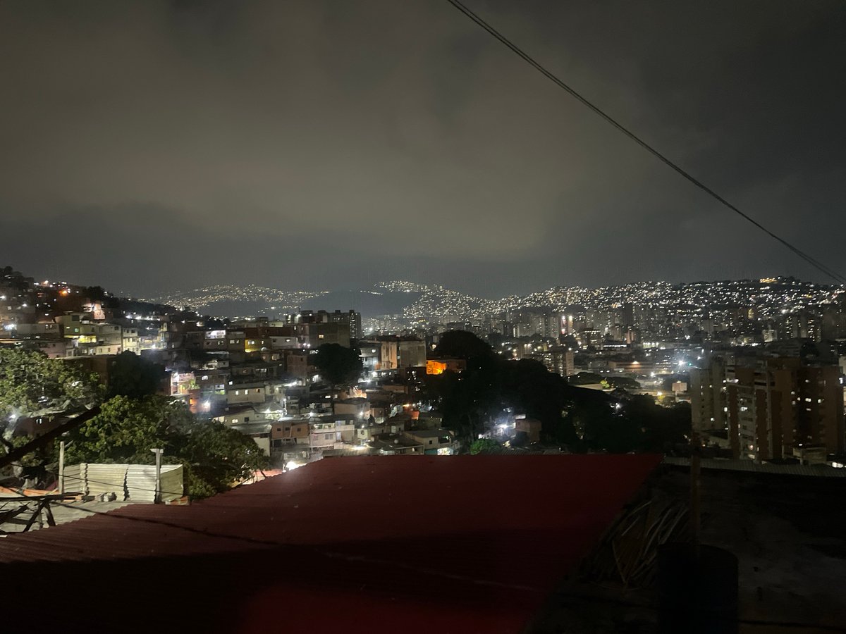 Nighttime view captures Caracas hillside housing under cloudy sky
